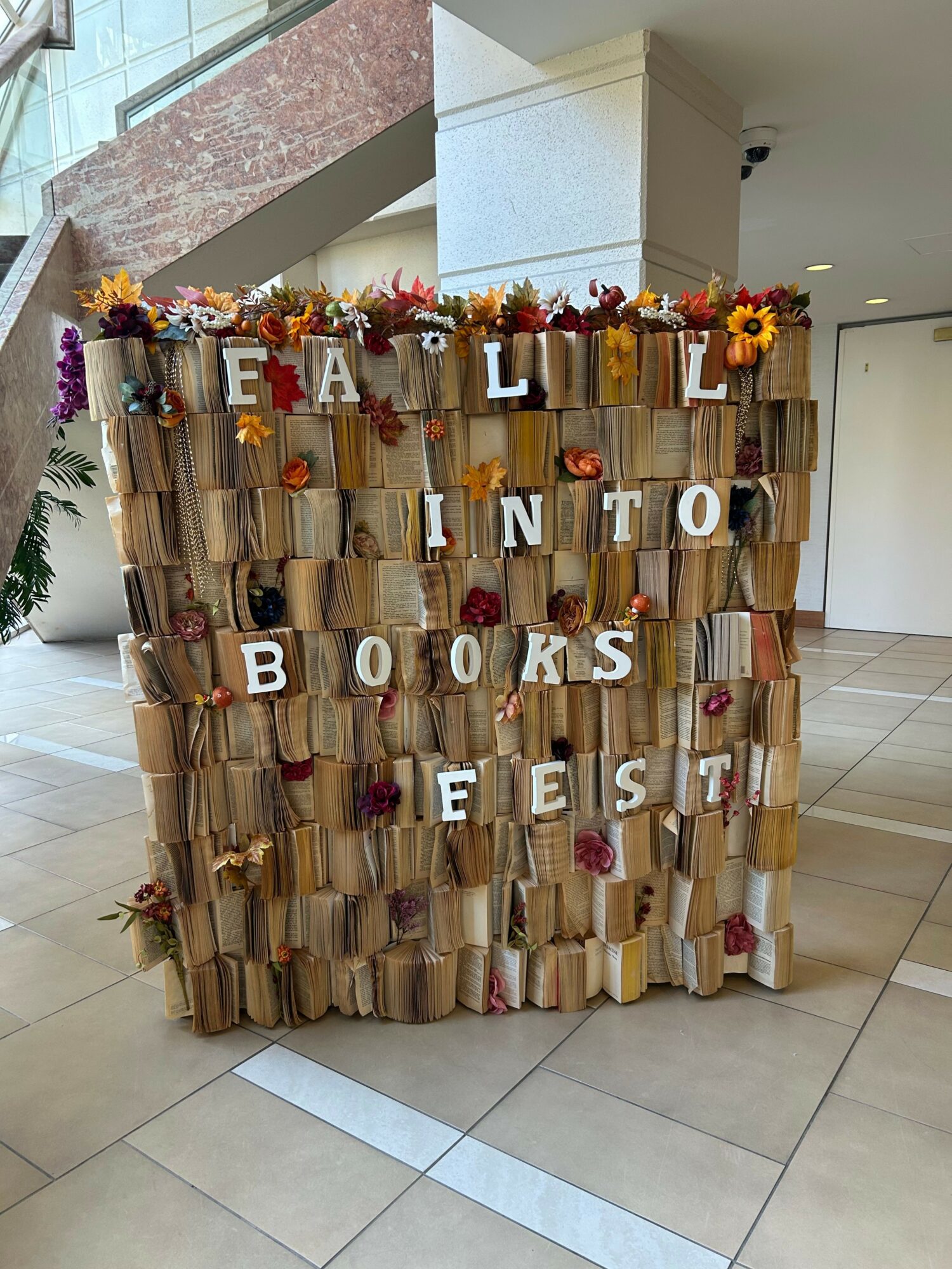 Book-themed display with flowers and letters spelling 