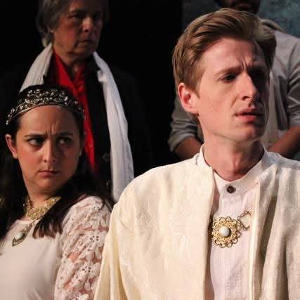 Three people, two women and one man, in period costumes, with serious expressions, indoors.