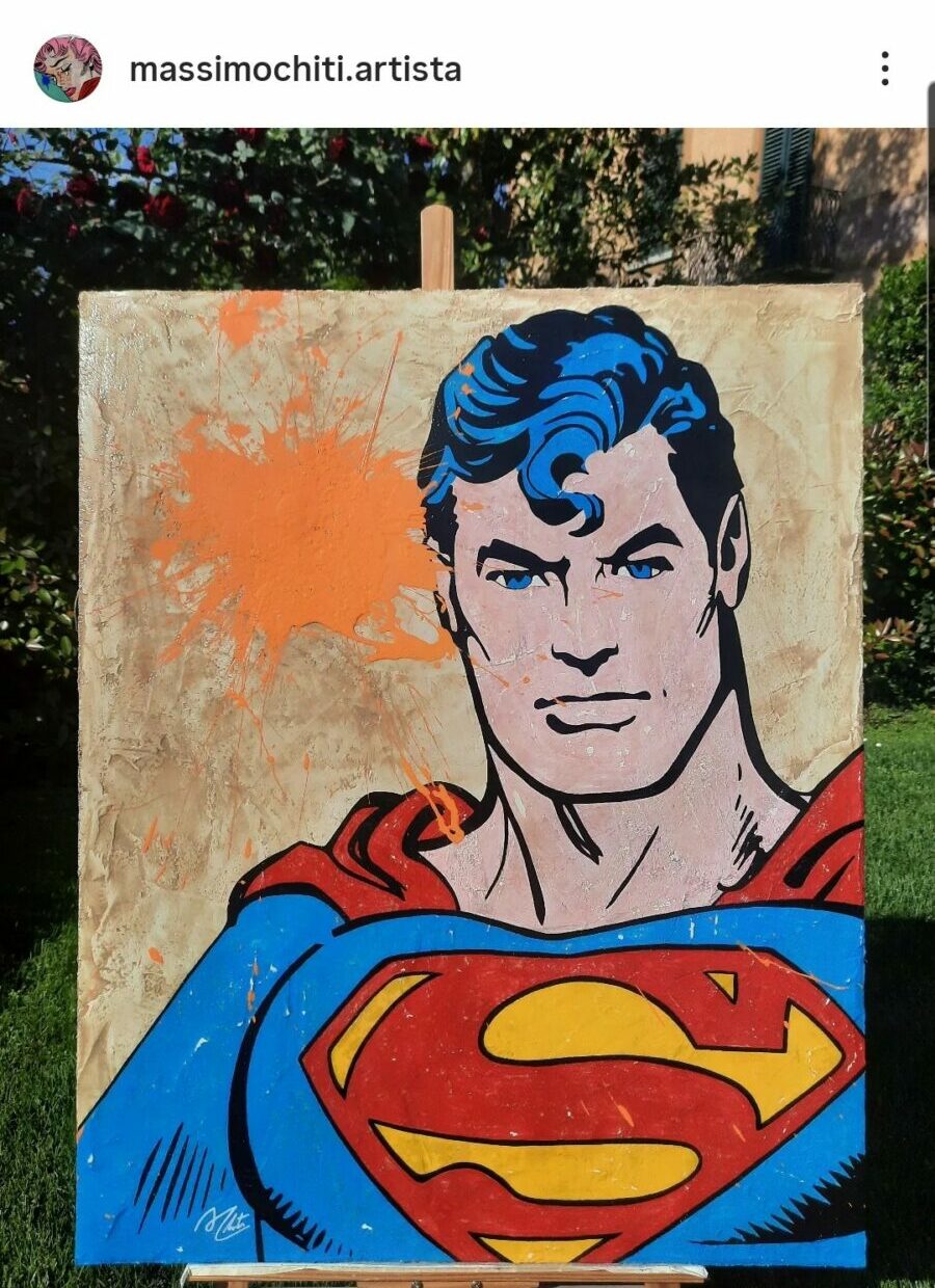 Colorful Superman painting on wooden board outdoors with trees in background.