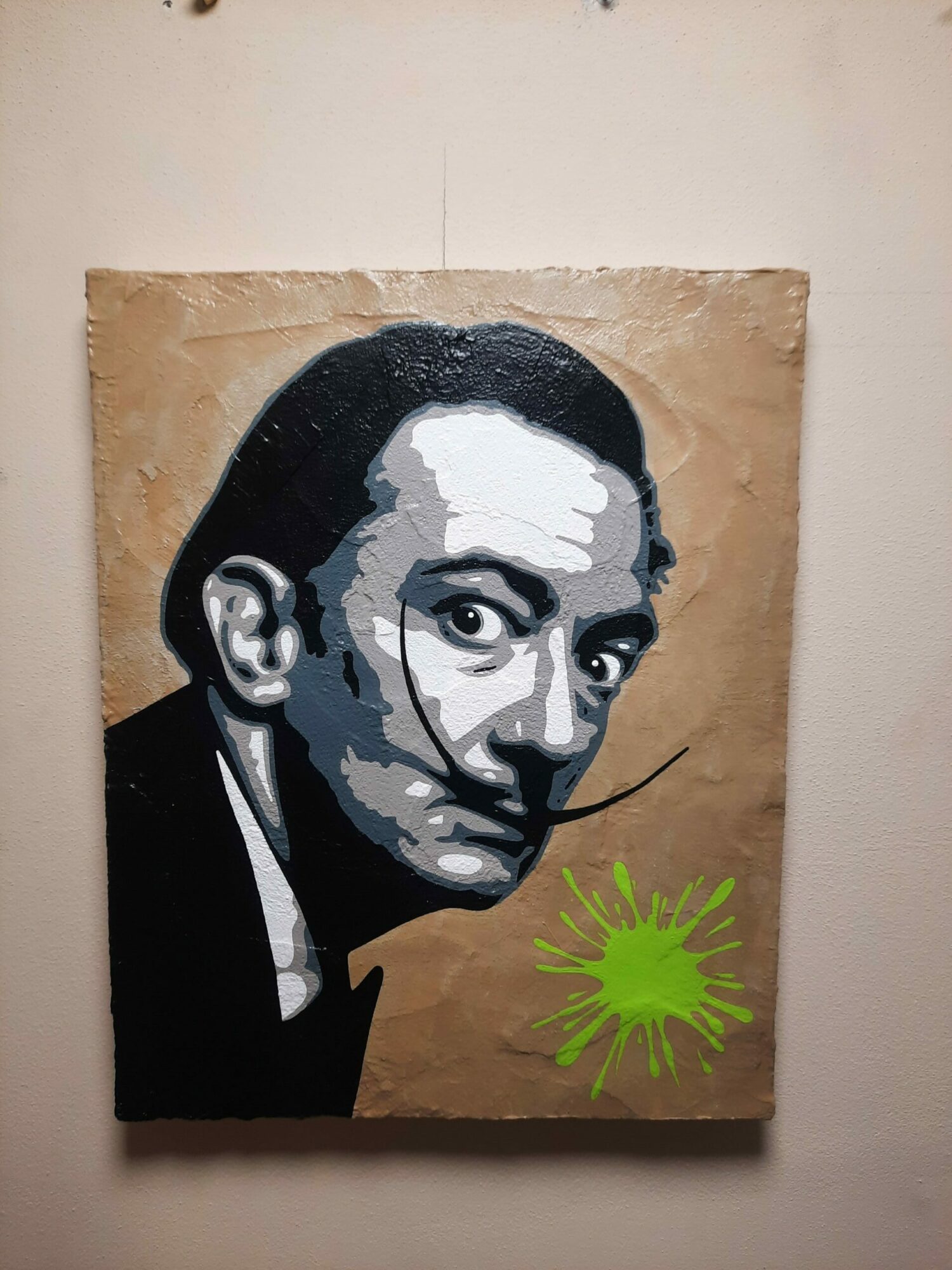 Graffiti-style portrait of a person's face with a green splatter in the top right corner on brown paper background.