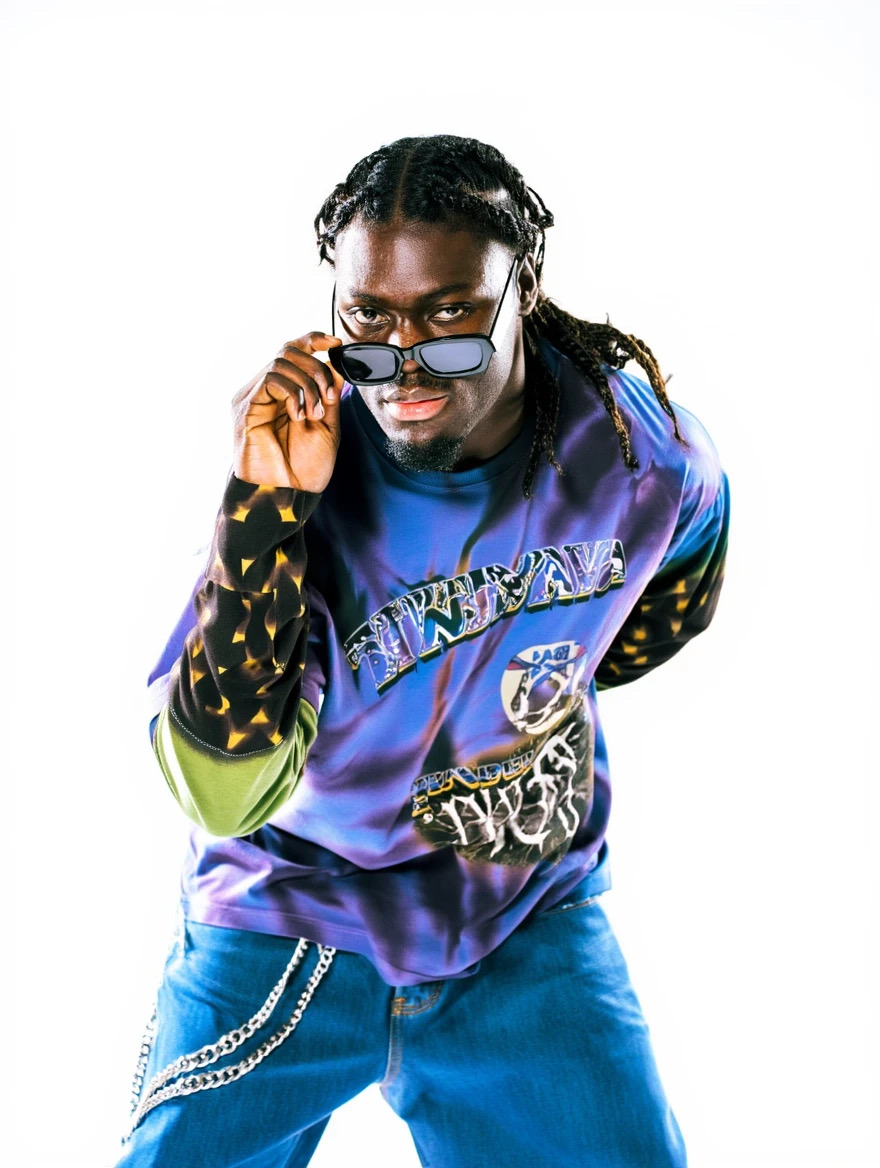 Person with glasses looking over sunglasses, wearing a colorful sweatshirt and jeans, against a white background.