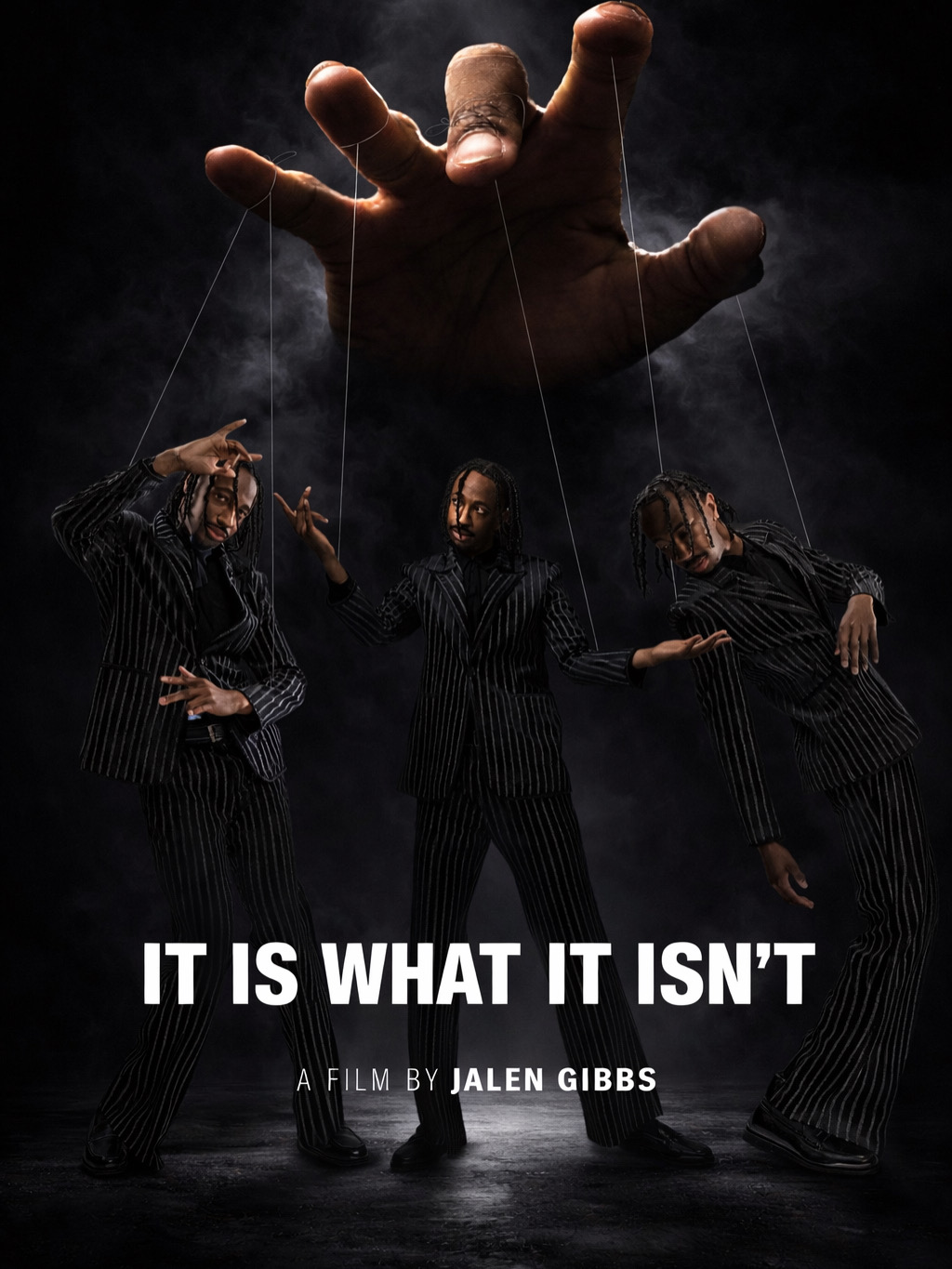 Three people in striped outfits are manipulated like marionettes by a large hand above them, with dark background.