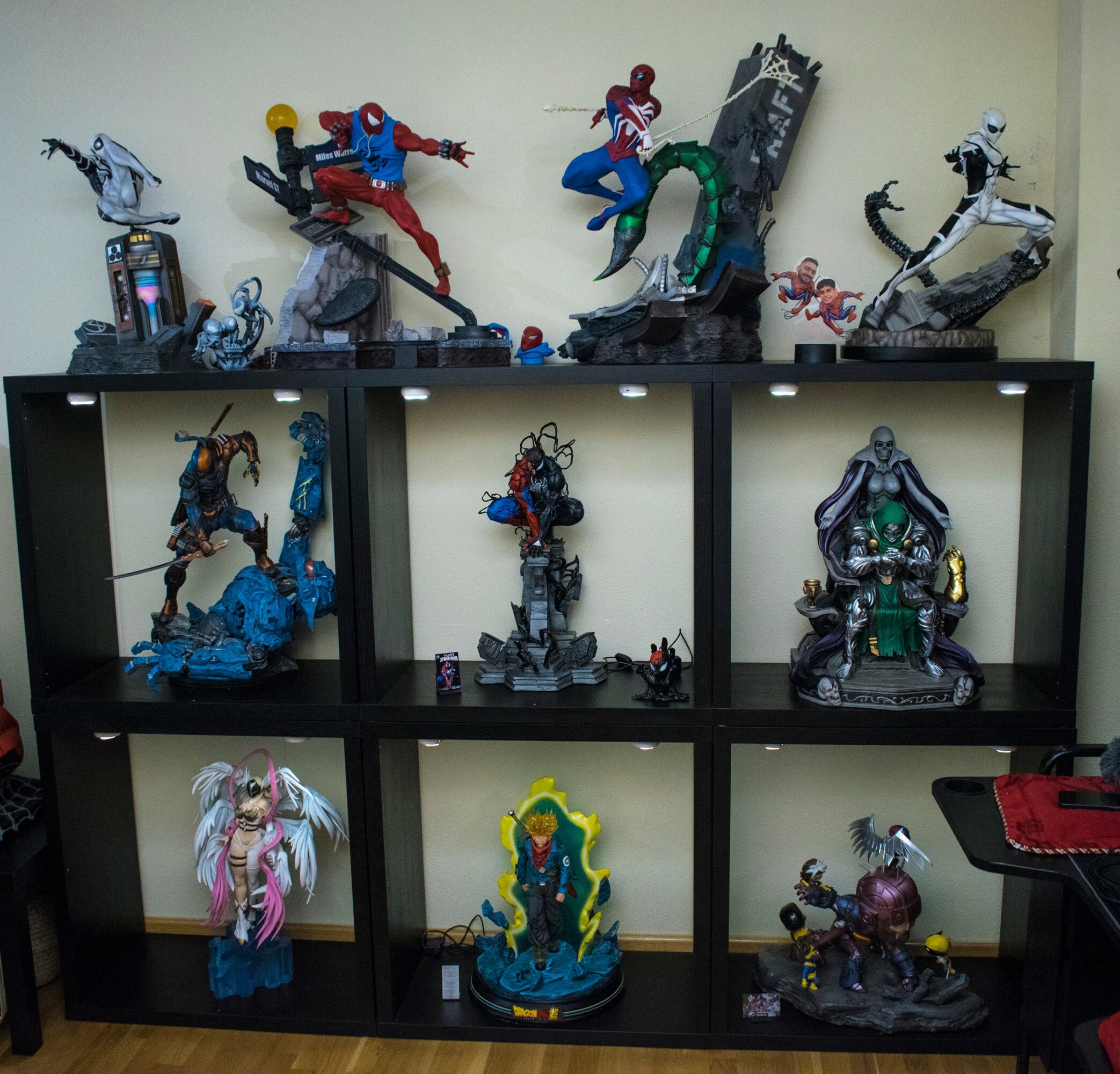 Display shelf with various superhero and character figurines, some on top and inside the shelves, against a light wall.