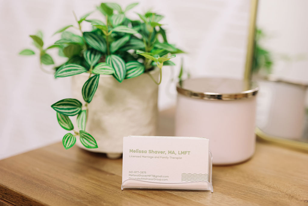 A potted plant with green striped leaves, a soap bar, and a pink container on a wooden surface.