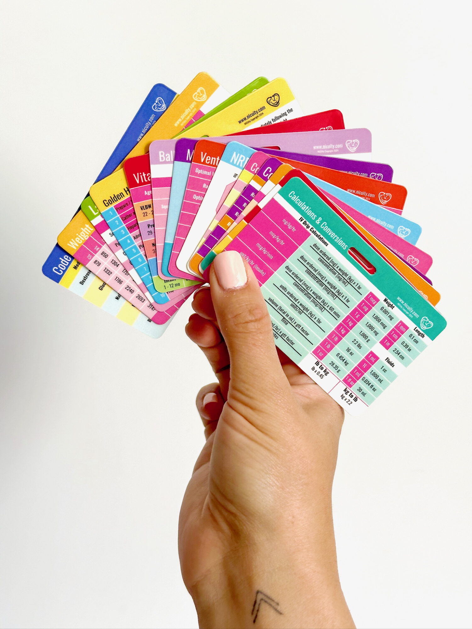 Hand holding multiple colorful cards fanned out, with text and numbers visible.