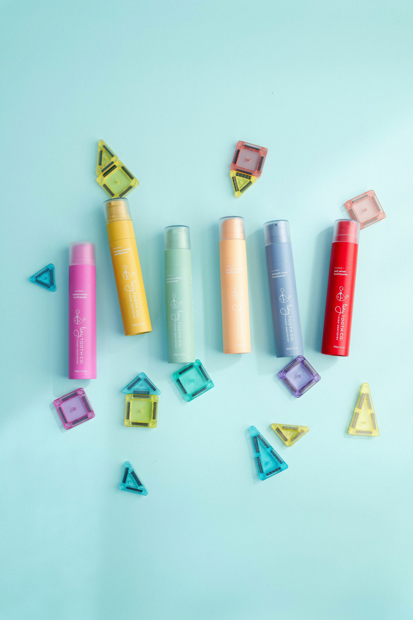 Colorful highlighters and small geometric shapes on a light blue background.