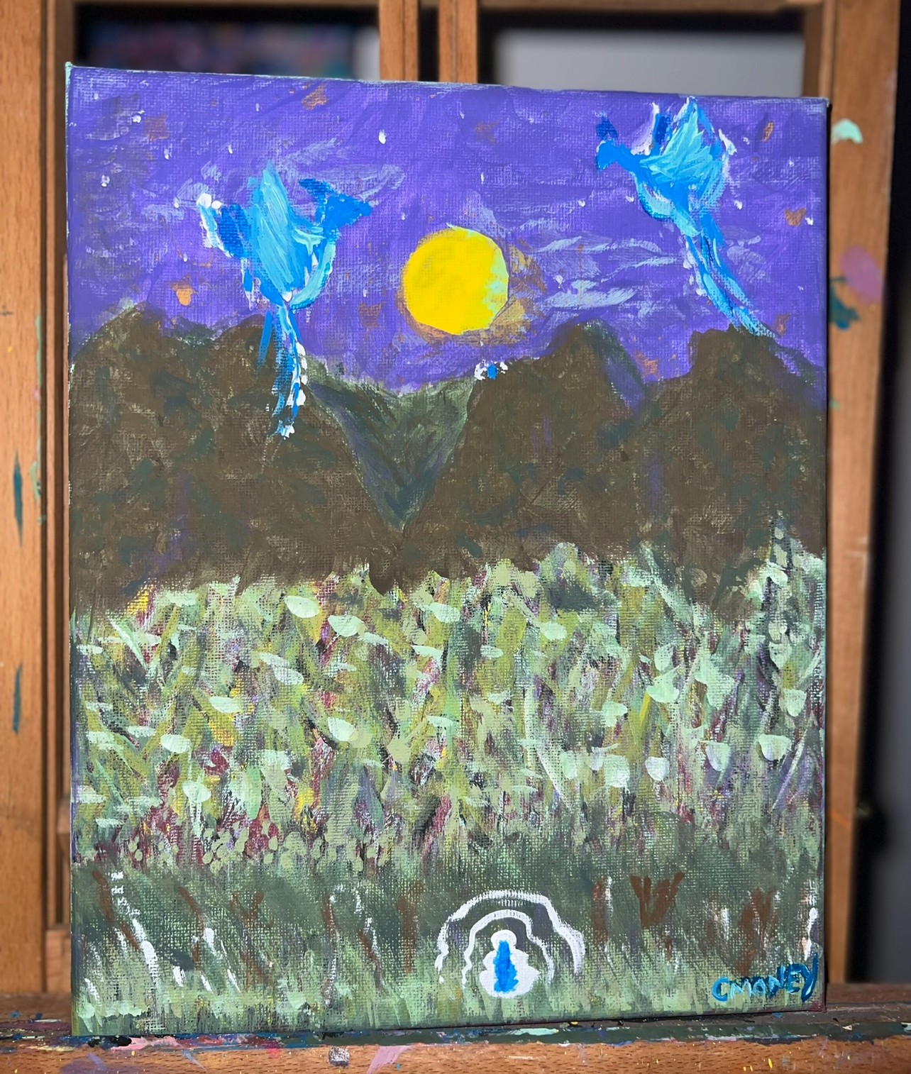 Painting depicts a purple sky with a yellow sun, mountains, a field, and two blue birds flying, with a small figure at the bottom.