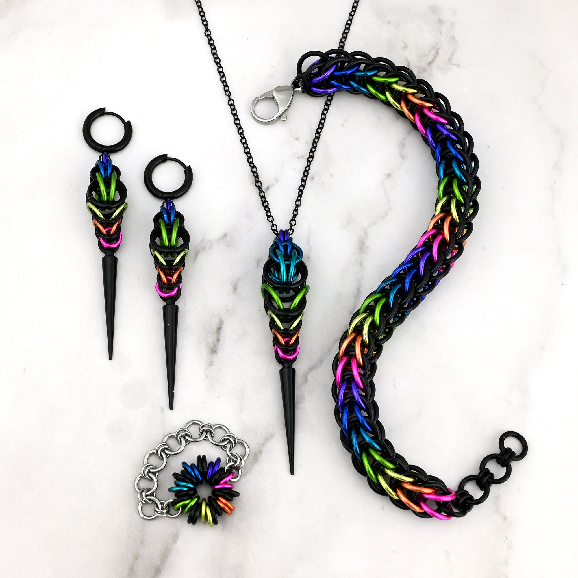 Colorful jewelry set with a necklace, earrings, bracelet, and ring on a white background.