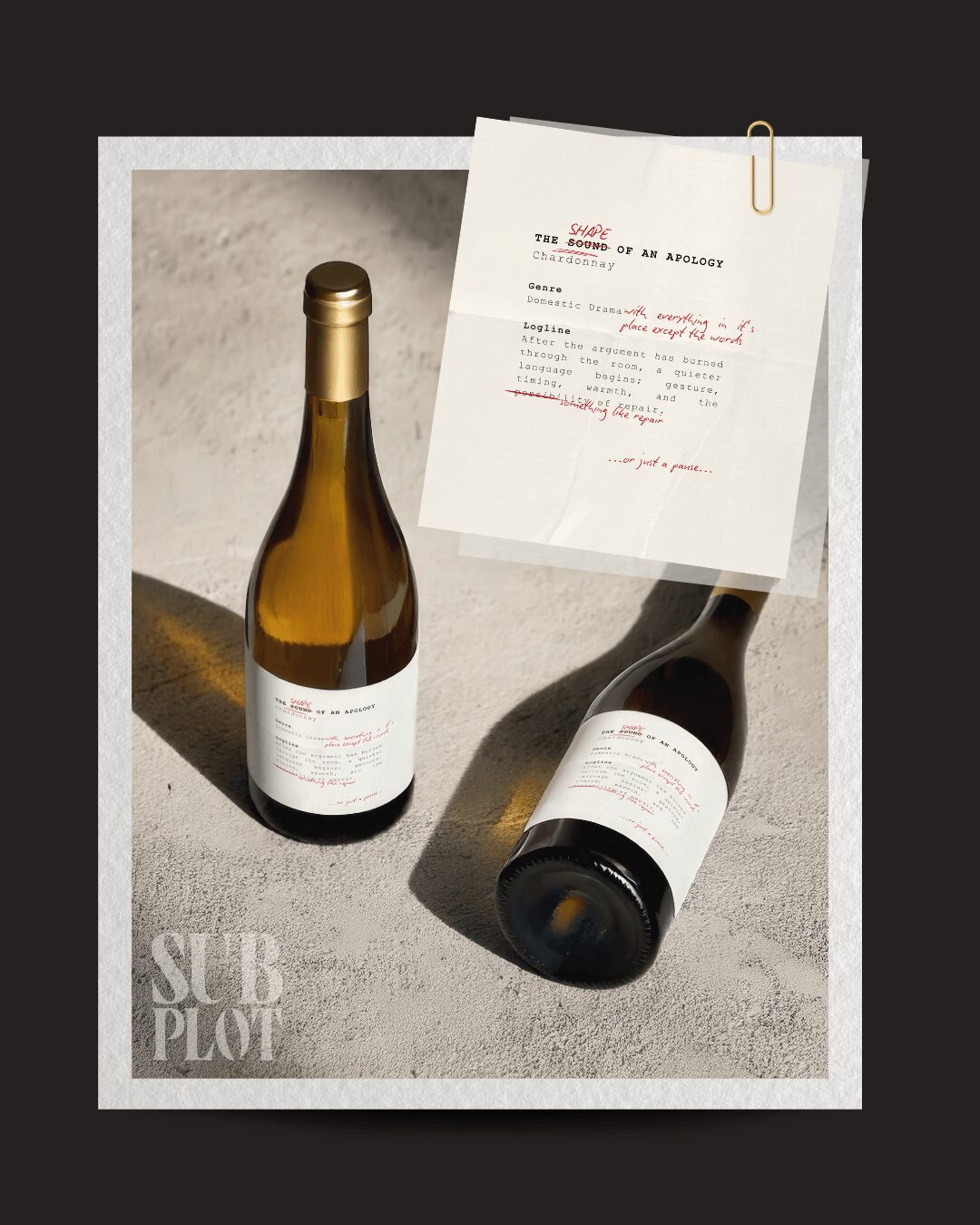 Two wine bottles on a surface with a note attached, one upright and one lying down, against a dark background.