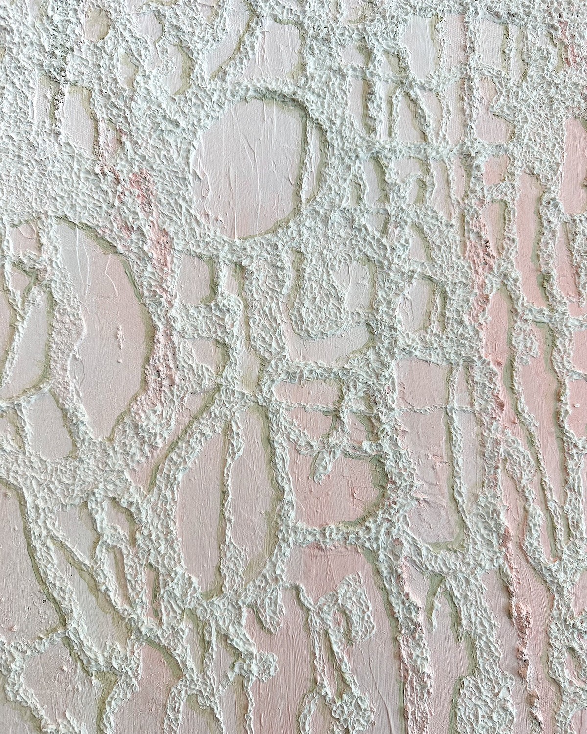 Close-up of textured wall with raised, irregular patterns and light pink and white colors.