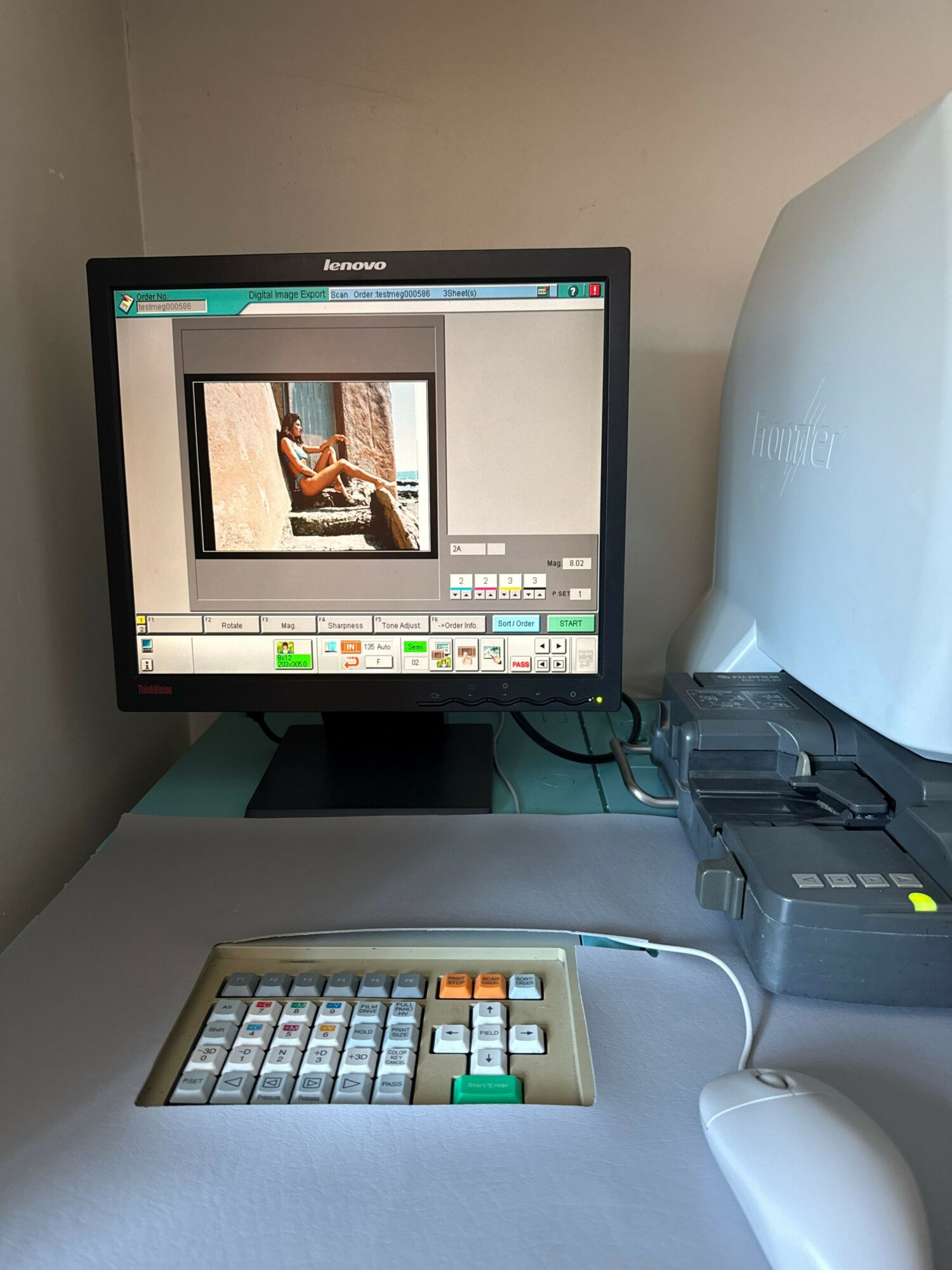 Computer monitor displaying editing software, keyboard, and electronic device on a desk, viewed from the side.