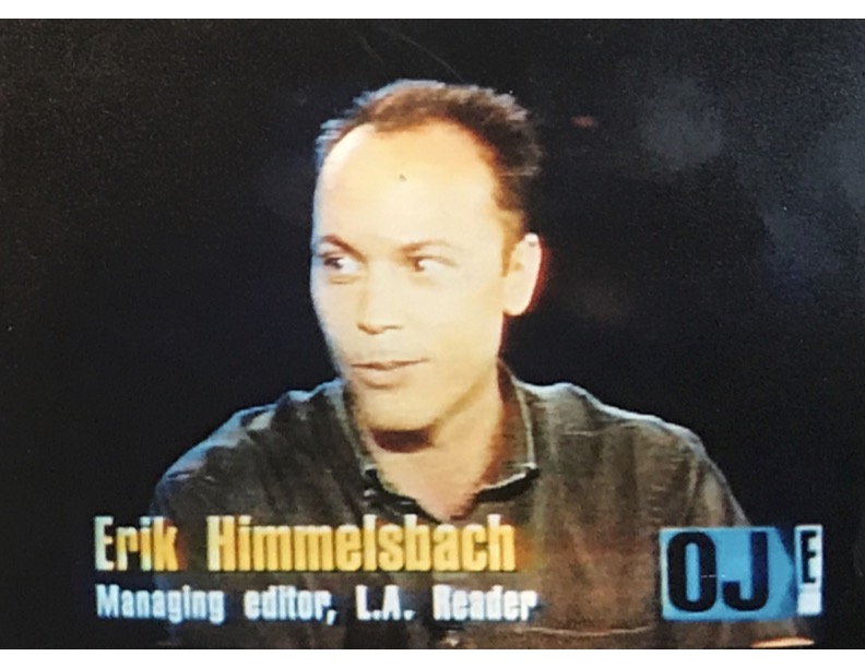 A man with short hair and a dark shirt, speaking on a television program, with text overlay including his name and title.