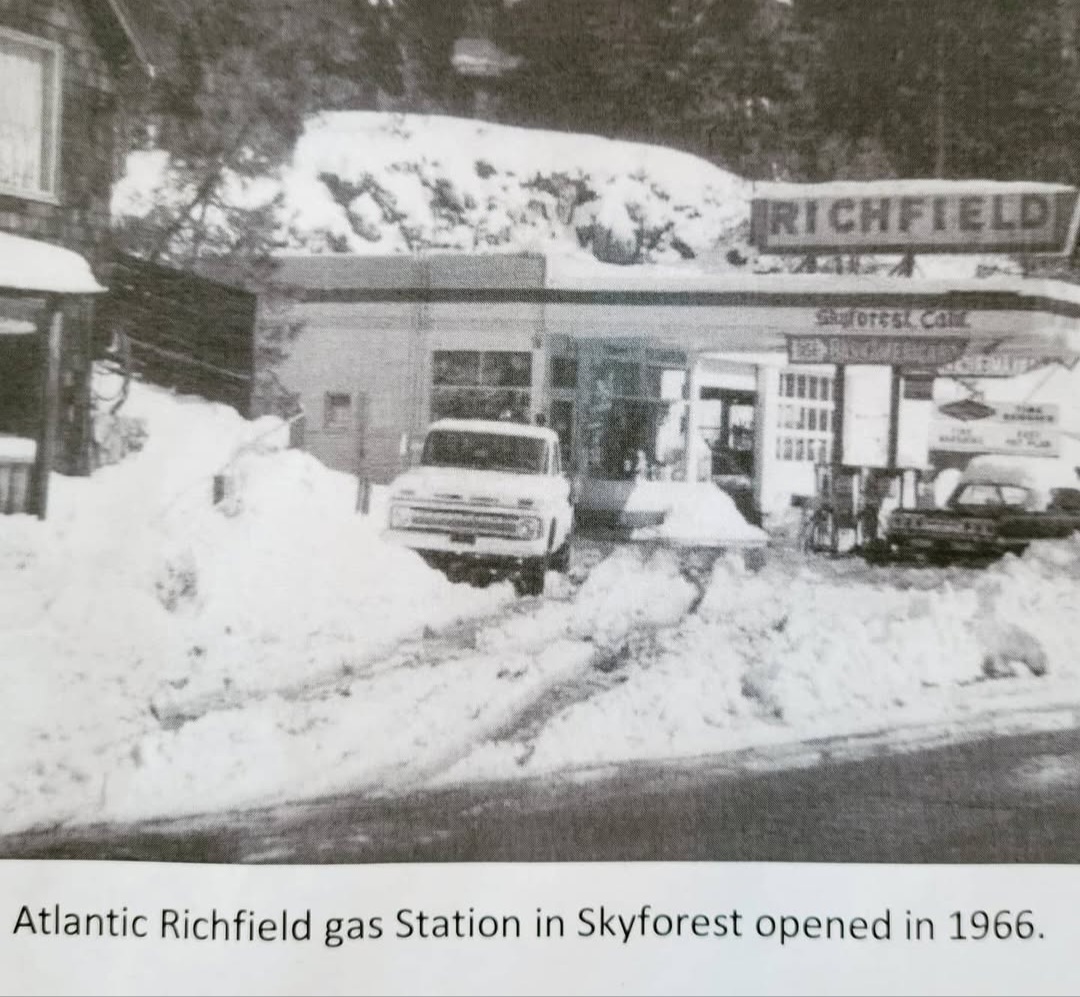 Gas station with cars parked in front, snow on the ground, and a sign reading 'Richfield' in the background.