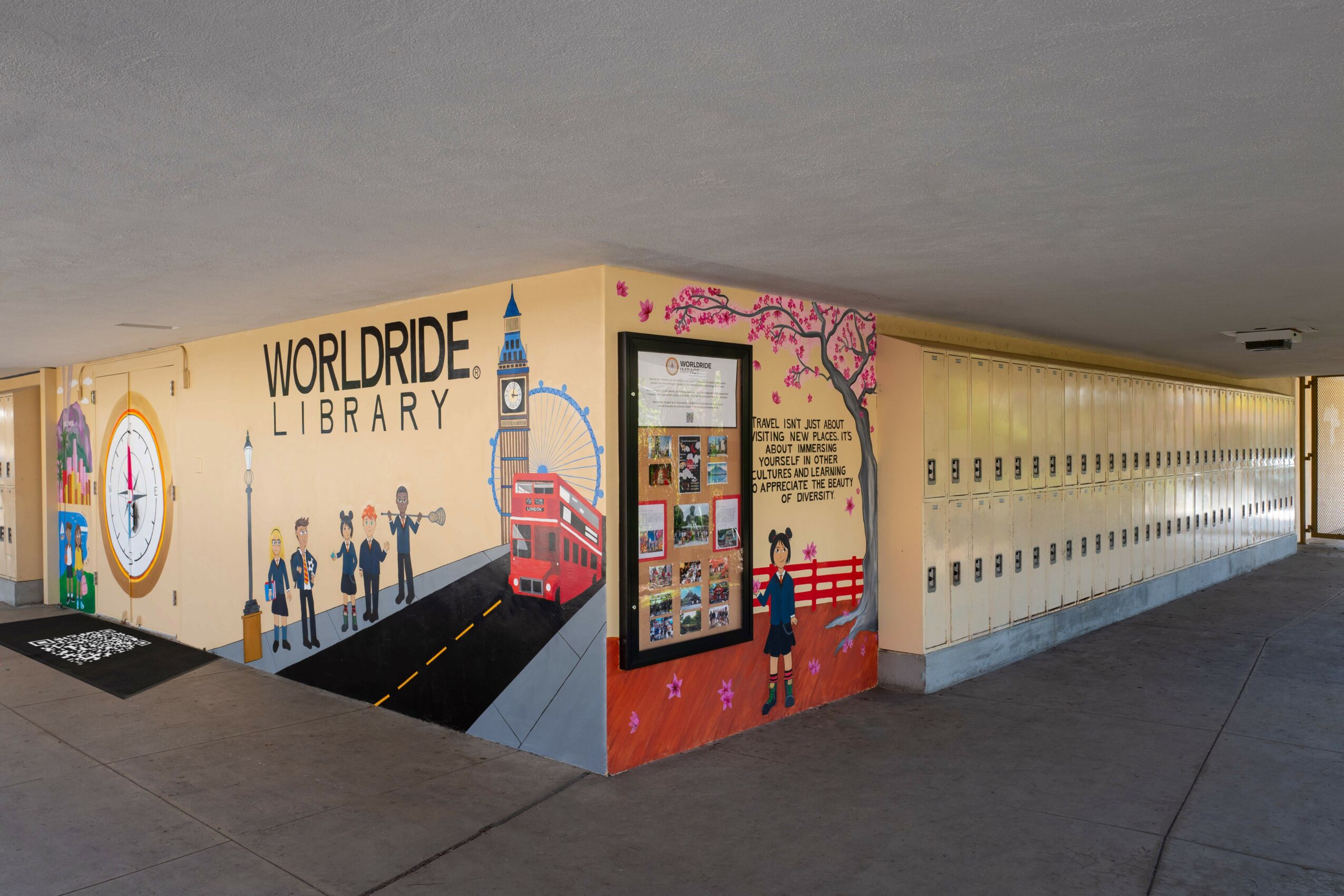 Colorful mural of a library with a clock tower, people, a red bus, and a pink flowering tree, with lockers along the wall.