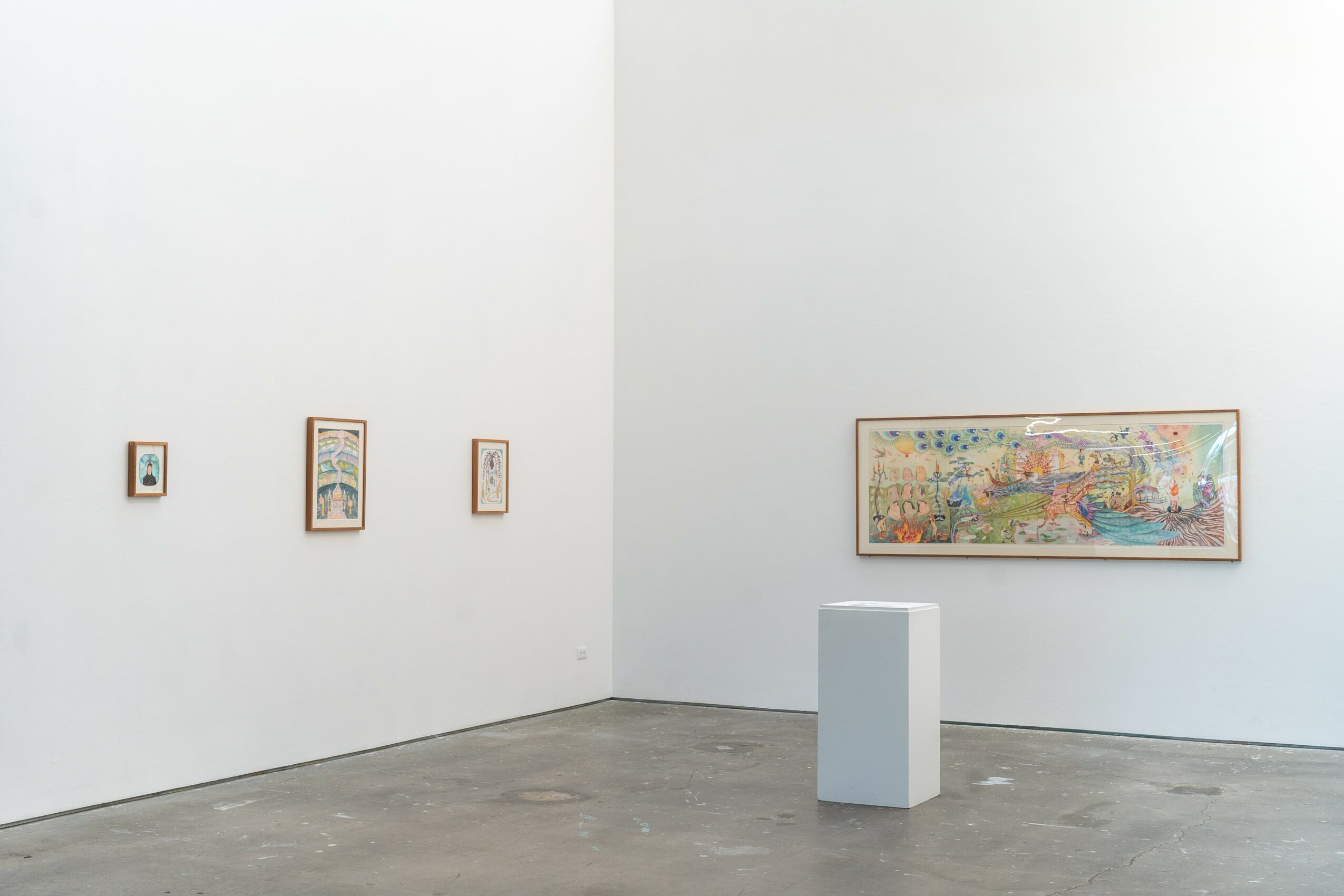 Gallery with three small artworks on the left wall and a large colorful painting on the right wall, with a white pedestal in front.