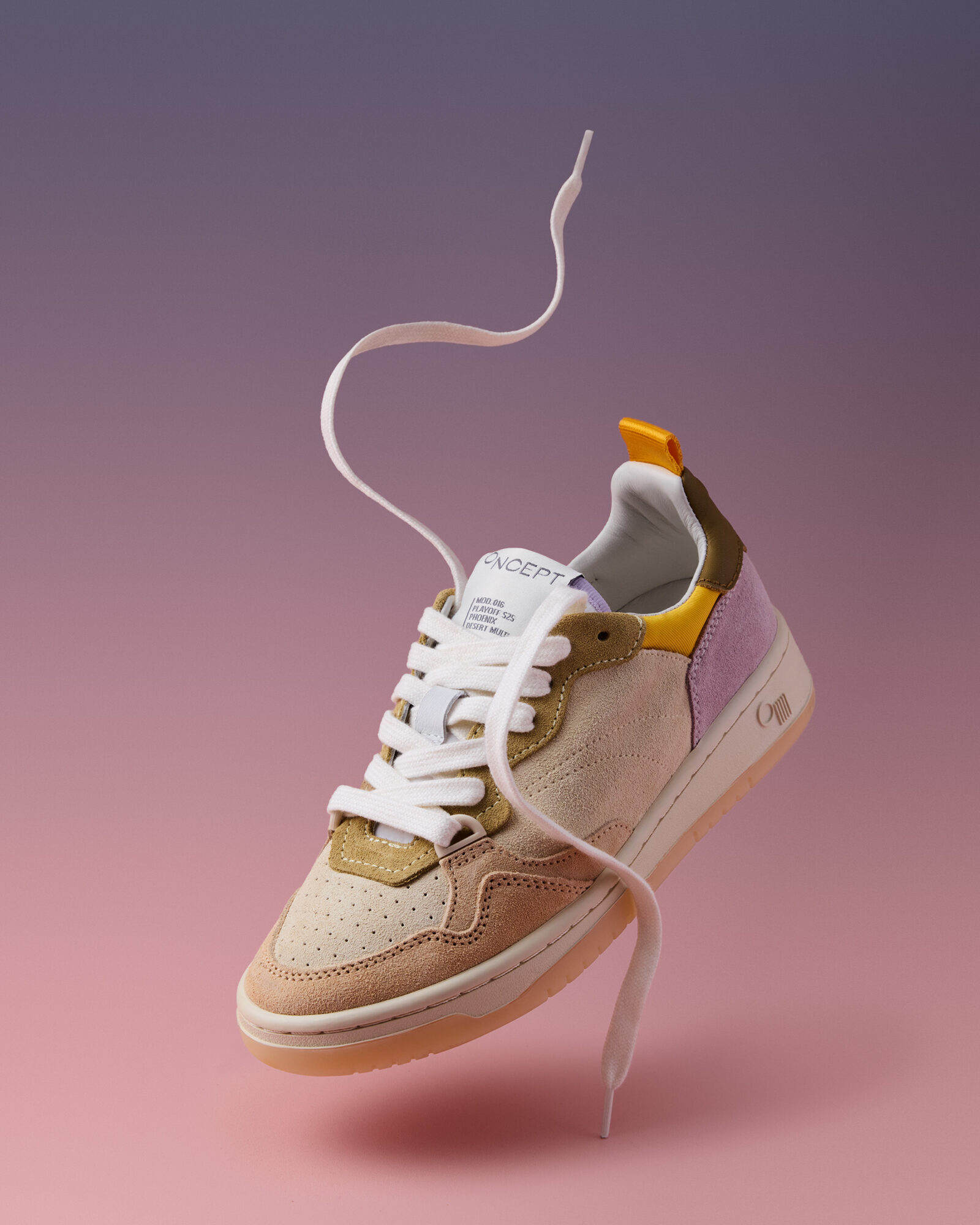 Sneaker with white laces, beige and yellow accents, floating against a pink and purple gradient background.