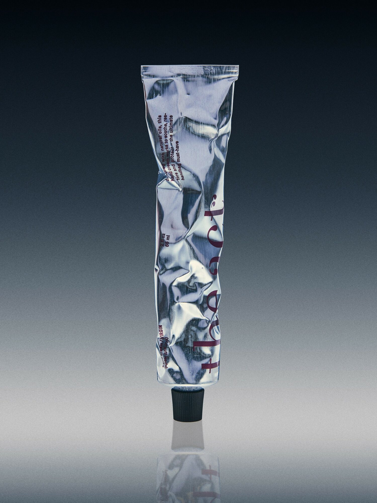 Crinkled metallic tube with black cap, standing upright against a gradient background.