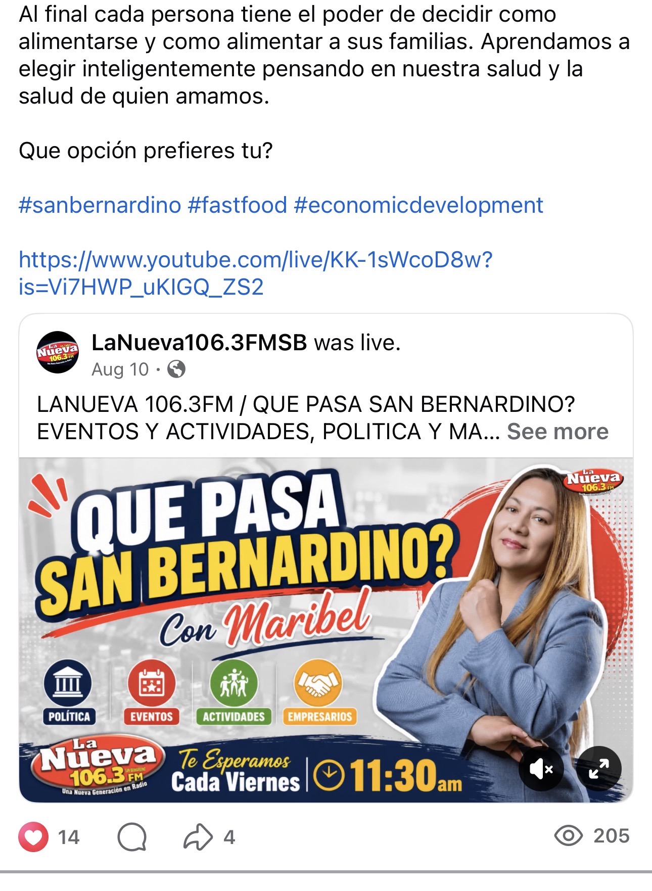 A woman with long hair in a blue blazer points to a colorful poster about San Bernardino events at 11:30 am, with logos and text.