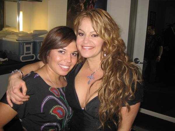 Two women smiling, one with short dark hair and the other with long wavy blonde hair, hugging each other.