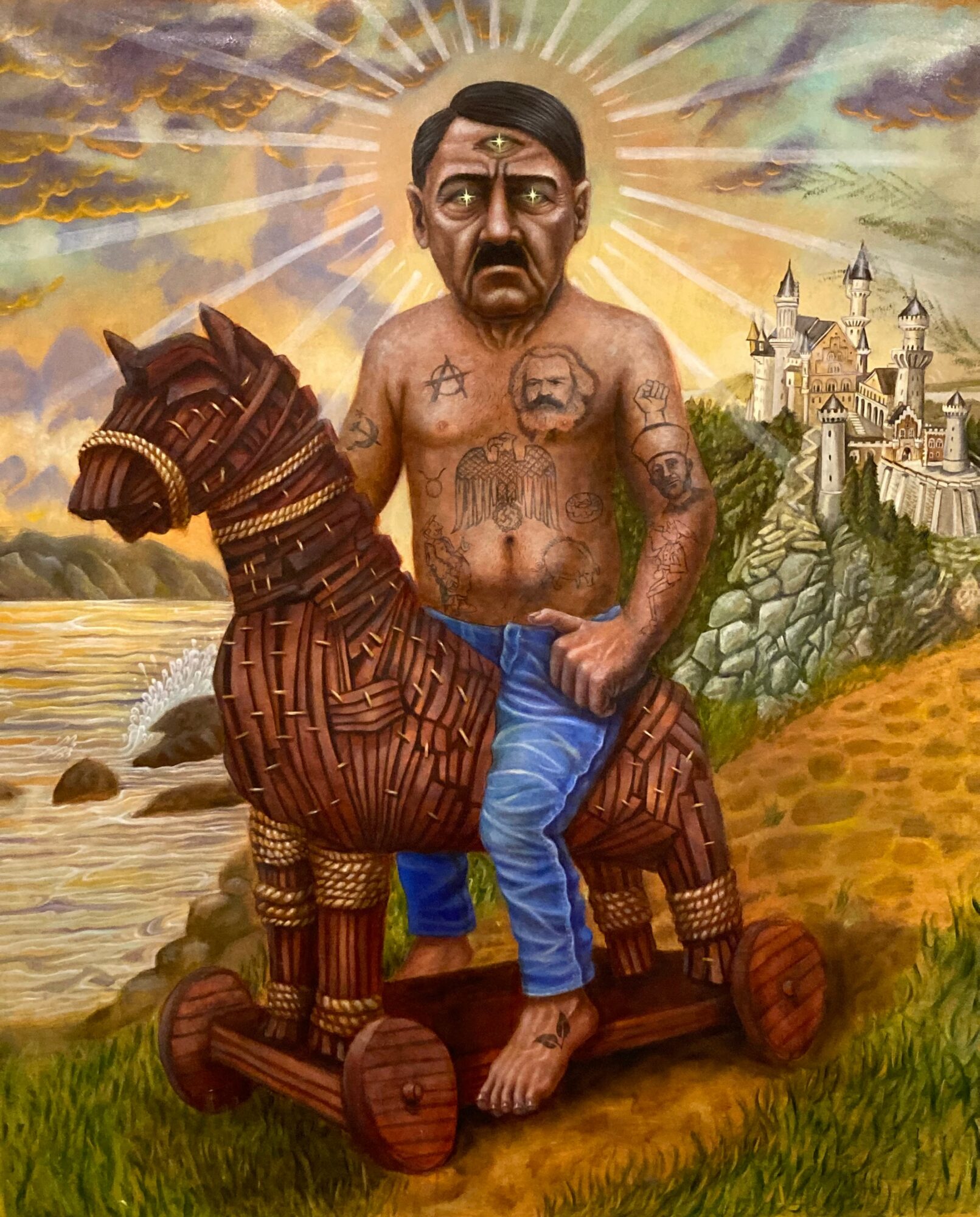 A man with tattoos rides a wooden horse on wheels, with a castle and landscape in the background.