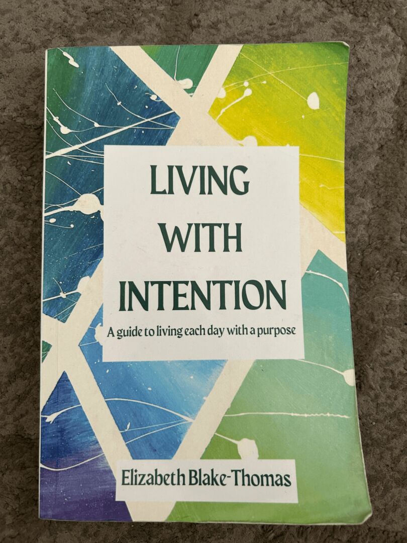 Book cover titled 'Living with Intention' by Elizabeth Blake-Thomas, with colorful abstract background.