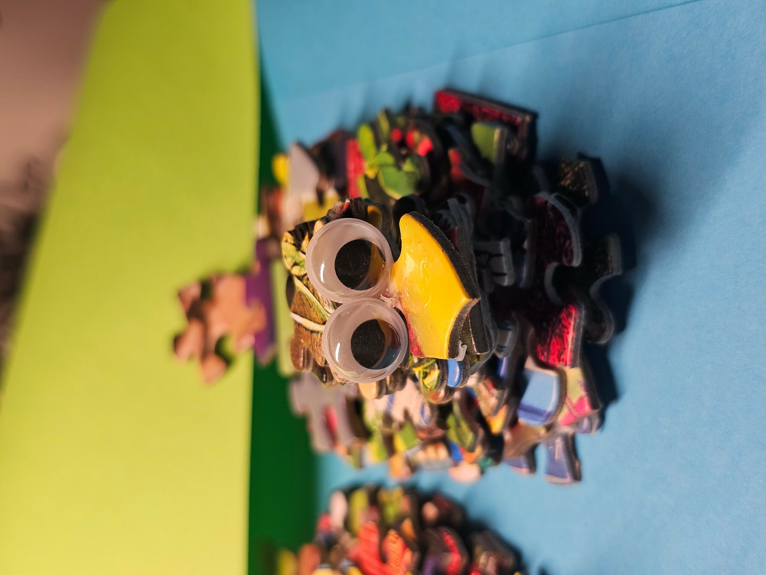 A pile of LEGO minifigure accessories and parts on a blue background, with some yellow and pink pieces visible.
