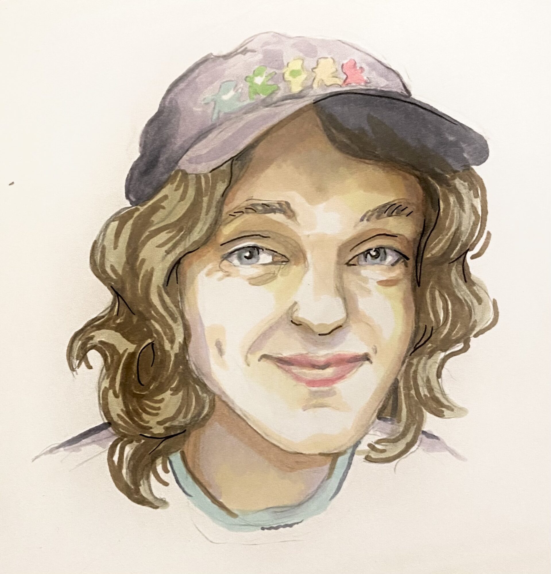 Portrait of a person with wavy hair wearing a cap with colorful decorations, smiling softly.
