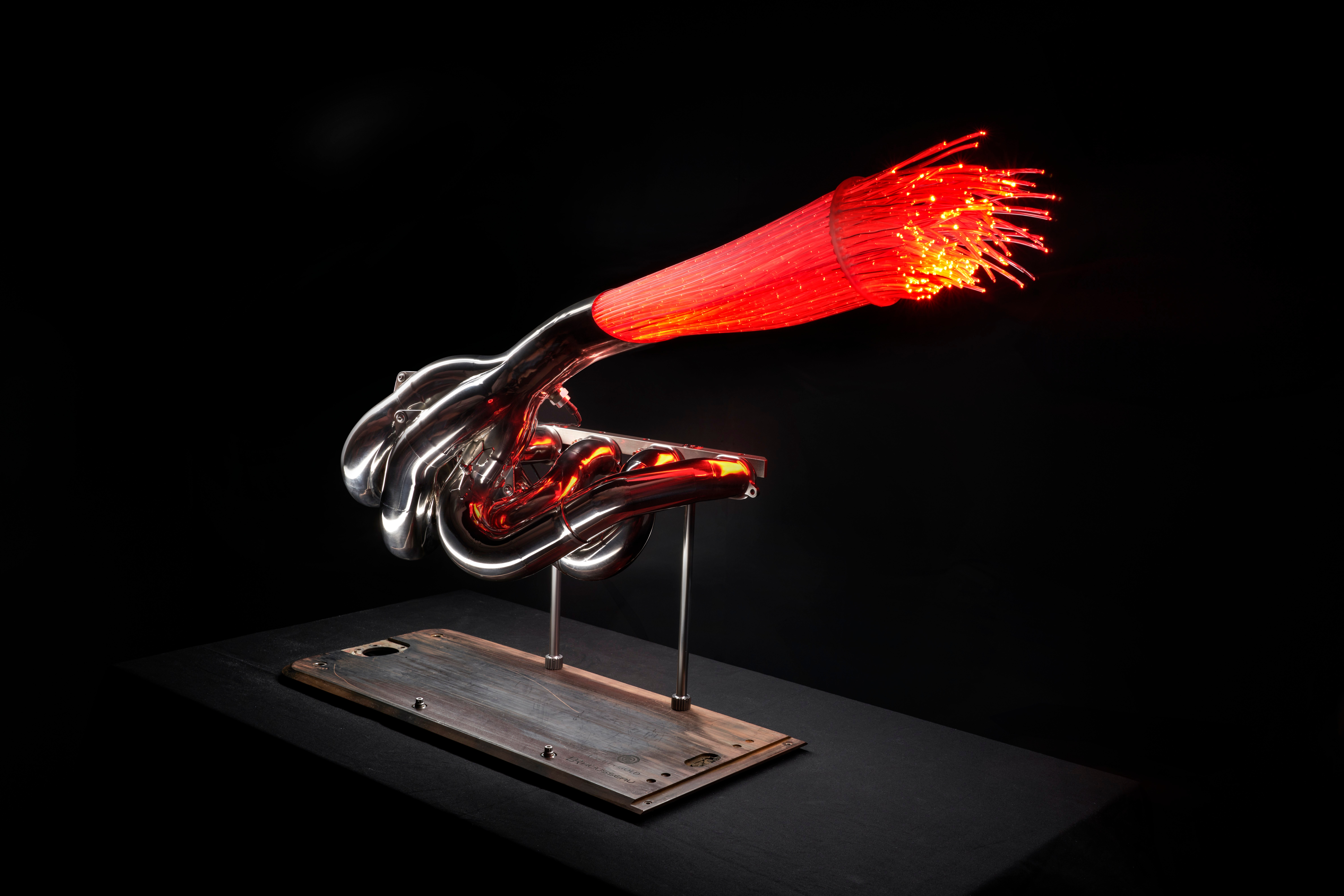 A scientific model of a nerve cell with a red and orange filament extending from the cell body, displayed on a black background.