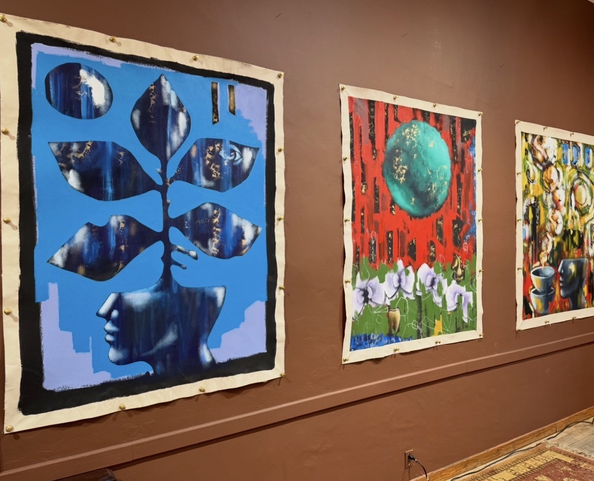 Three colorful abstract paintings on a brown wall, featuring geometric shapes, a large sphere, and vibrant patterns.