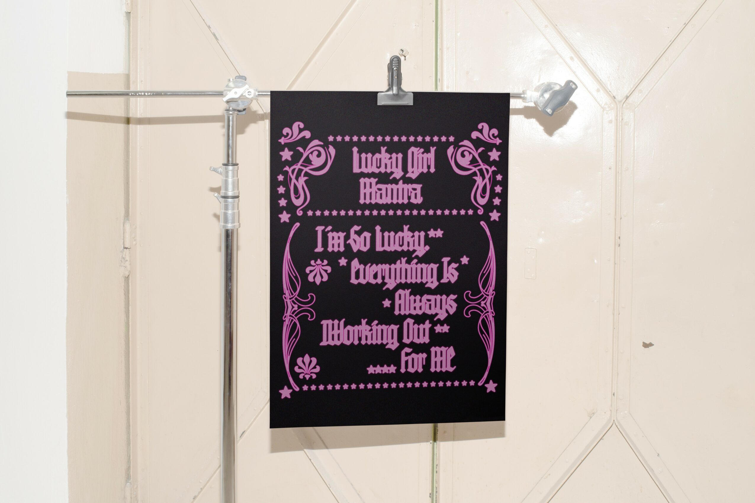 Black sign with pink decorative text and designs, reading 'Lucky Girl Maureen, I'm so lucky, everything is always thrilling out for me,'