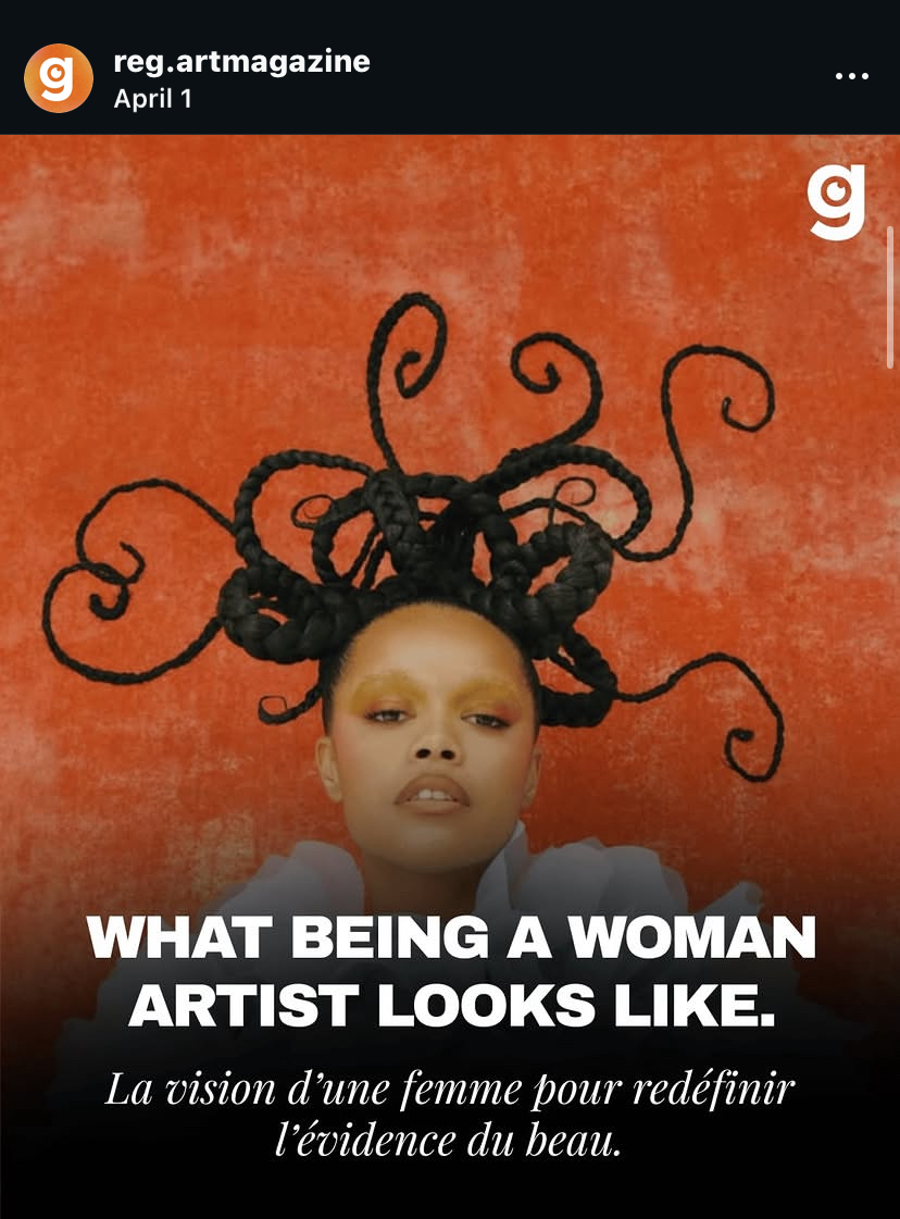 A woman with elaborate black hair styled in intricate, curly shapes against an orange background. She has makeup and a serious expression.