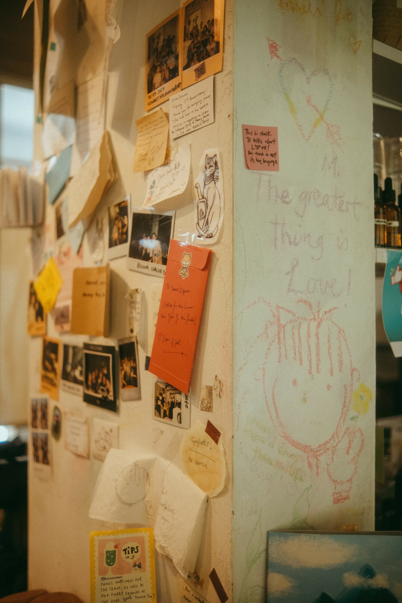 Wall with photos, notes, and drawings, including a large whiteboard with a smiley face and colorful scribbles.