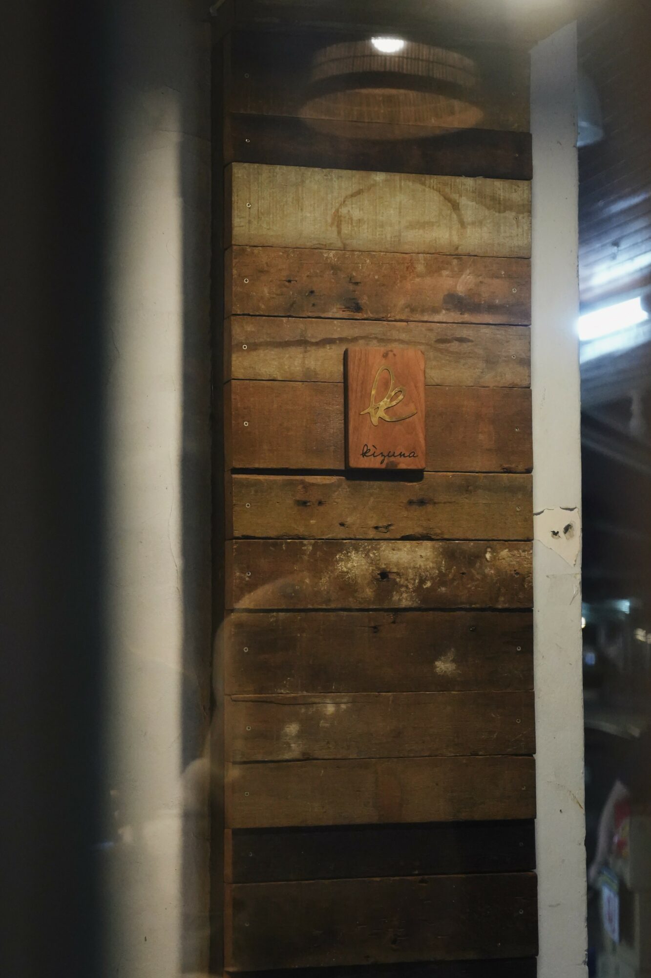 Wooden wall with a small framed picture hanging in the center.