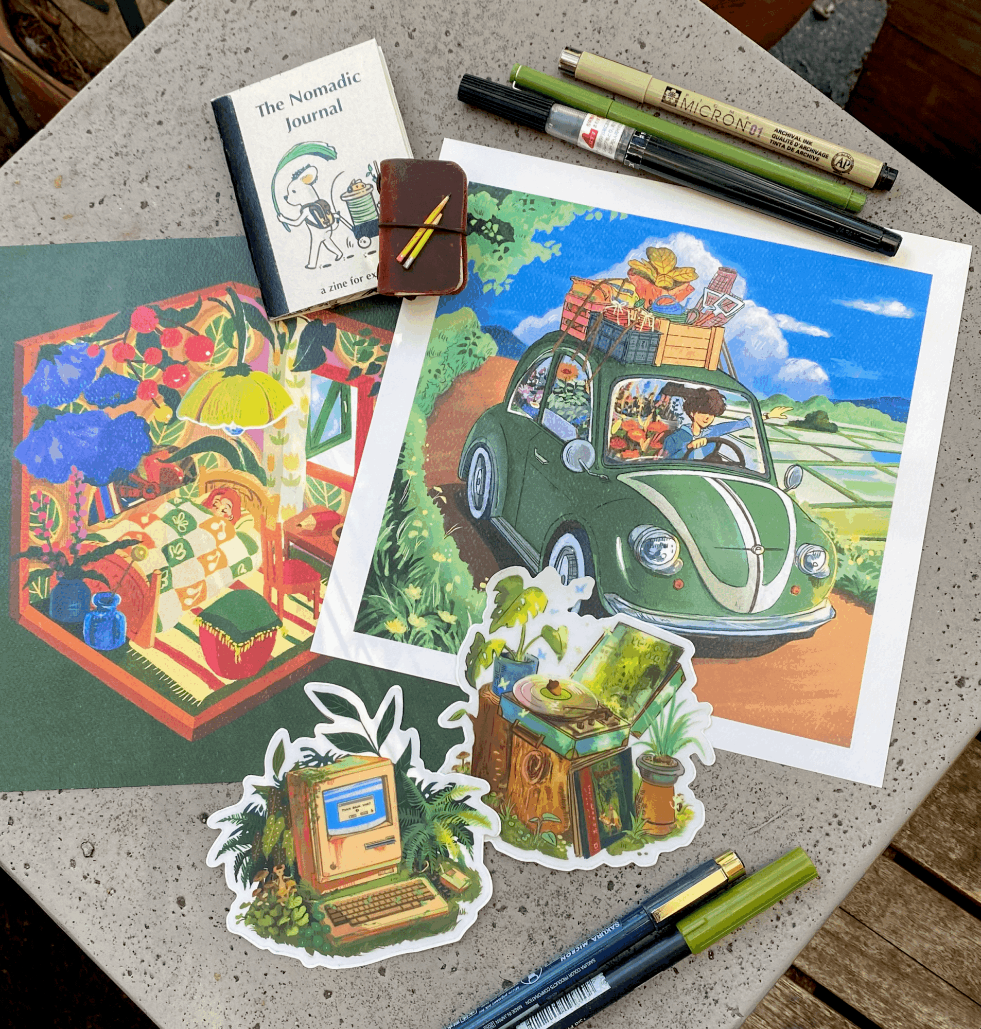 Colorful illustrations and printed images of plants, a car, and a book on a table with pens nearby.