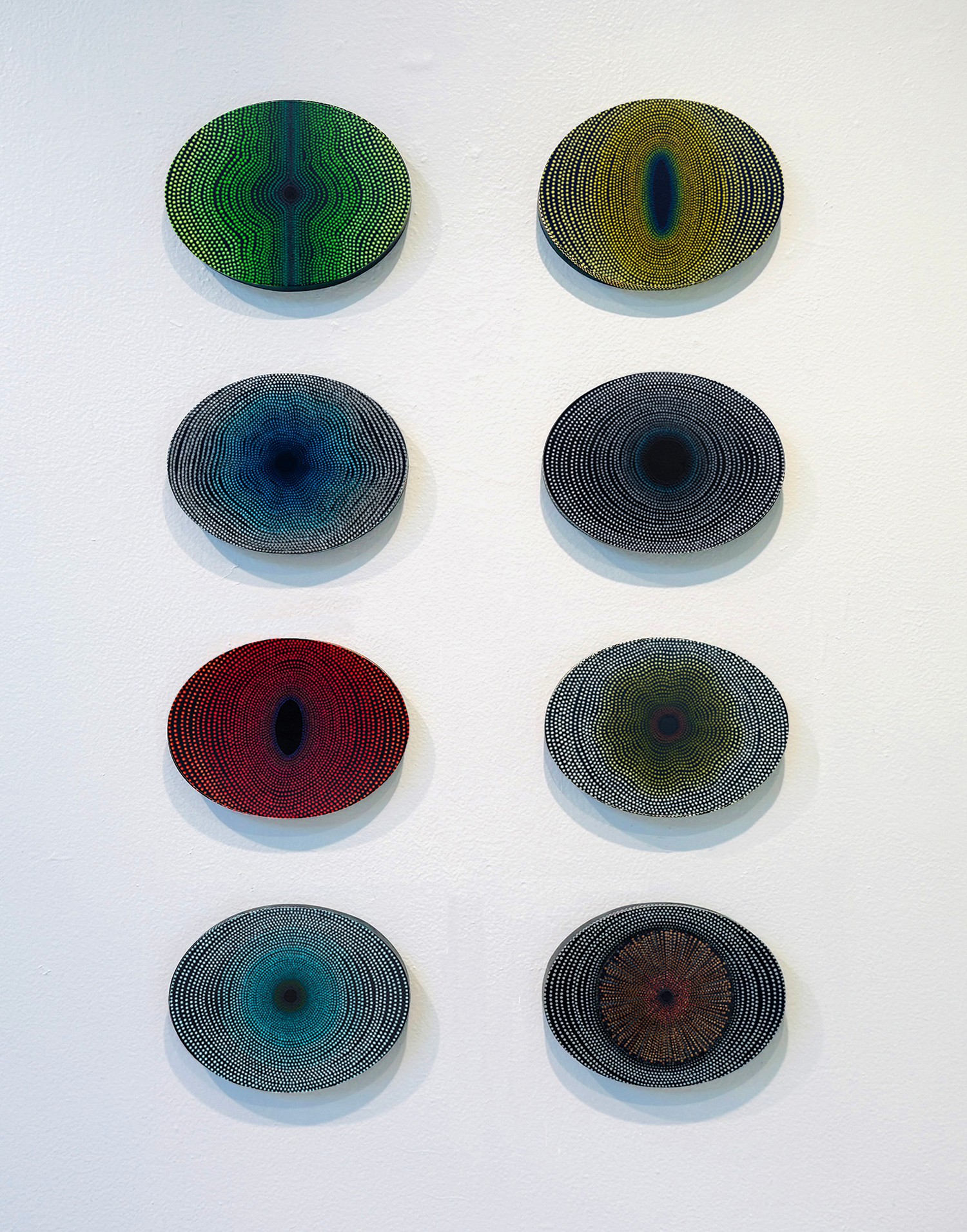 Eight oval-shaped objects with colorful concentric rings arranged in two columns and four rows on a white background.