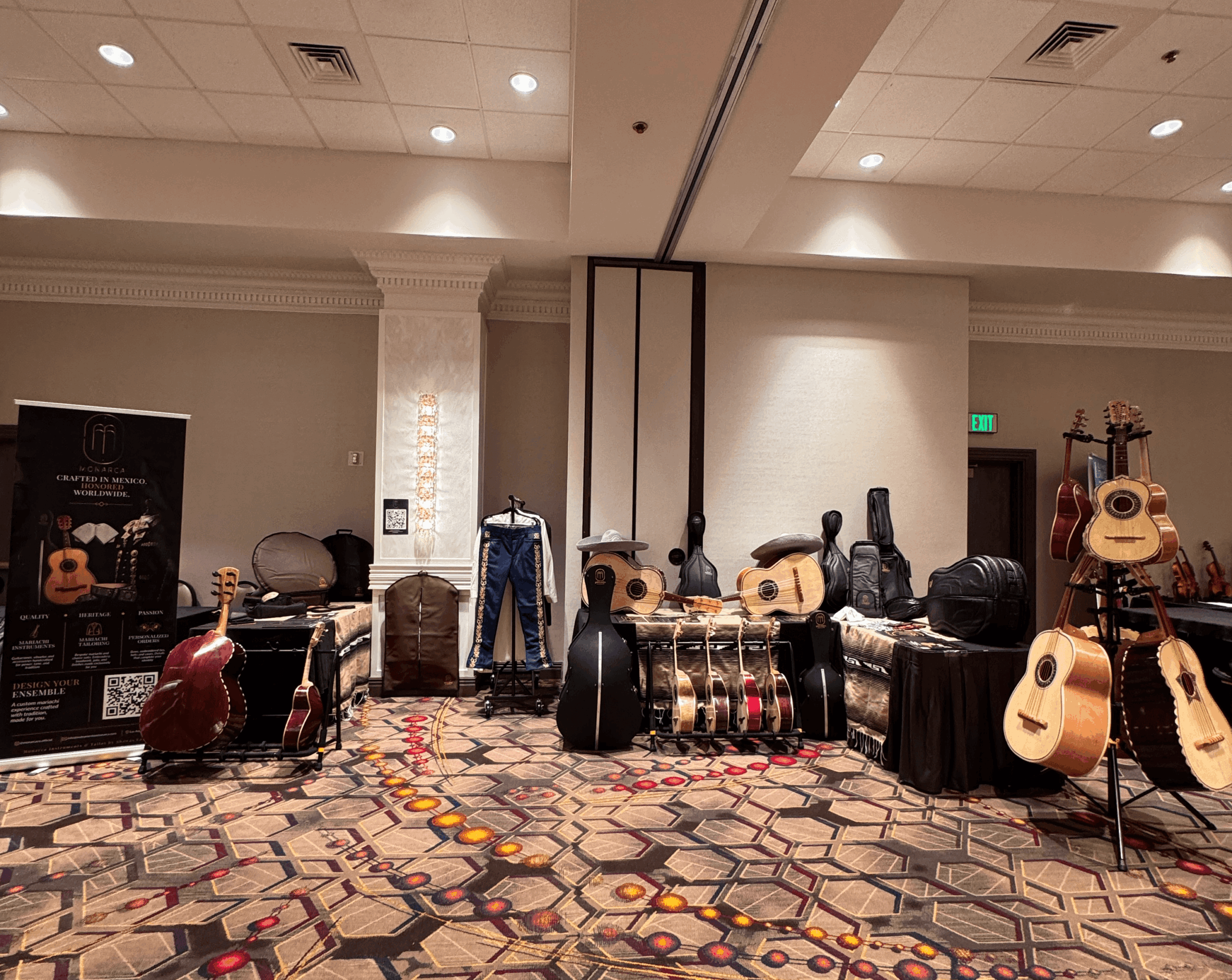 Music instruments and equipment displayed in a room with patterned carpet and plain walls.