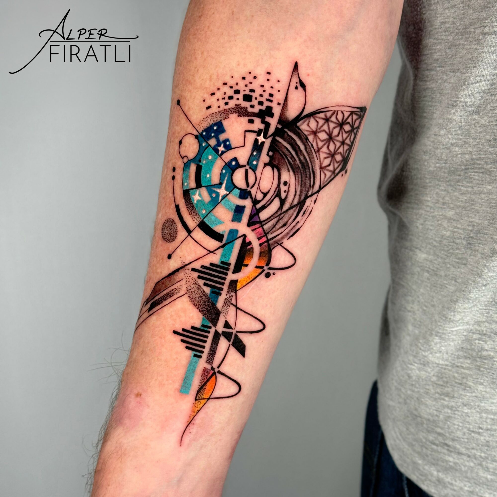 Abstract geometric tattoo with lines, circles, and patterns on a person's forearm.