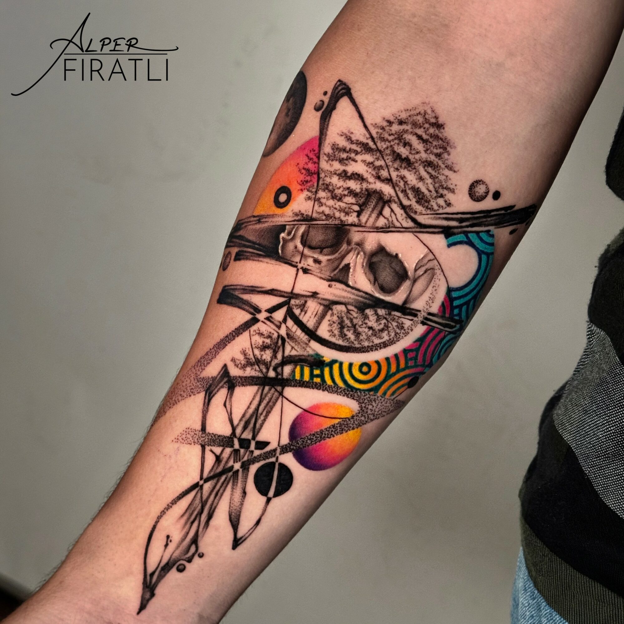 Tattoo of a butterfly, tree, and abstract colorful patterns on person's arm.