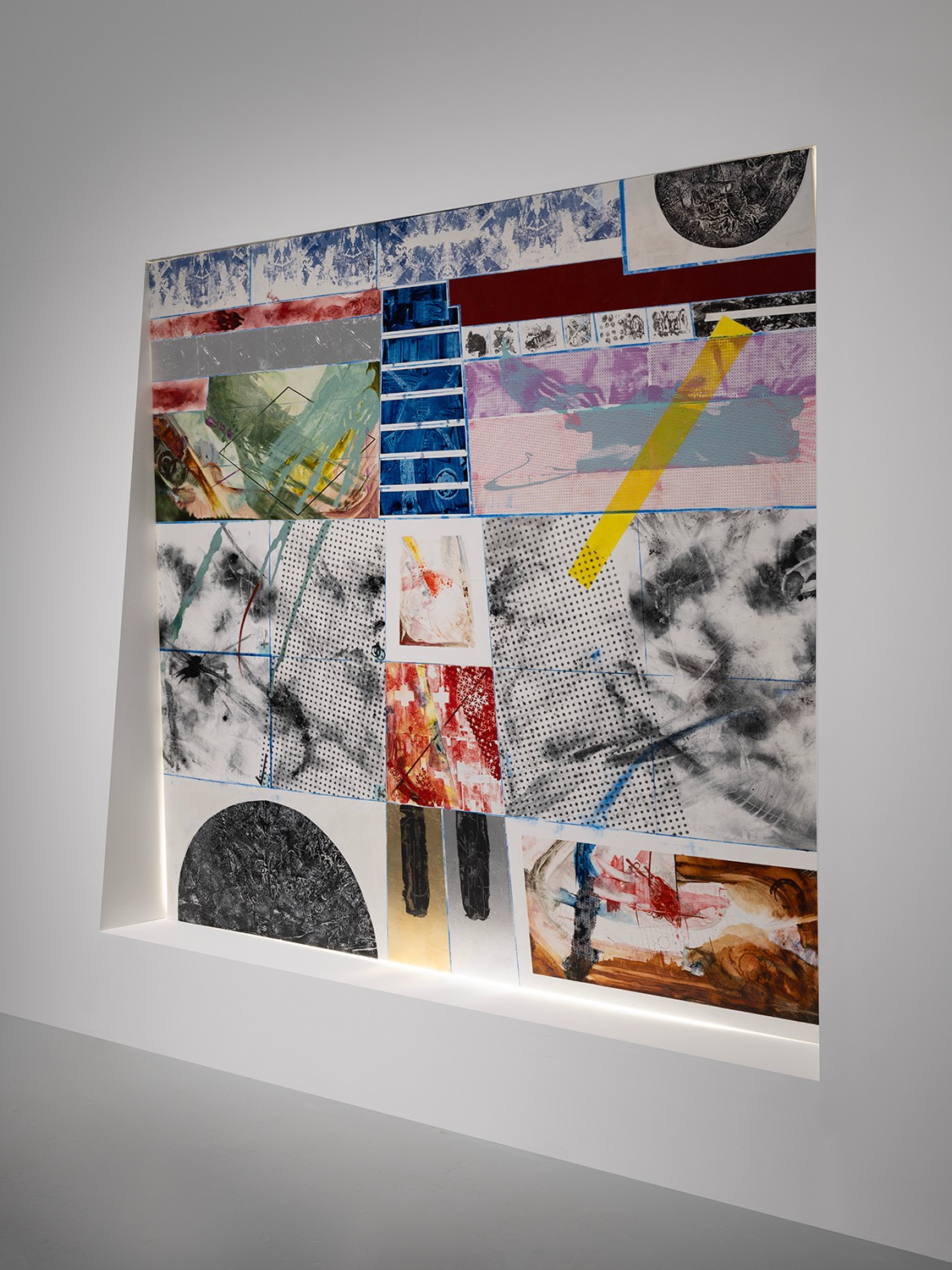 Mixed media artwork with abstract shapes, colors, and textures on a white wall, featuring geometric patterns and splashes of color.