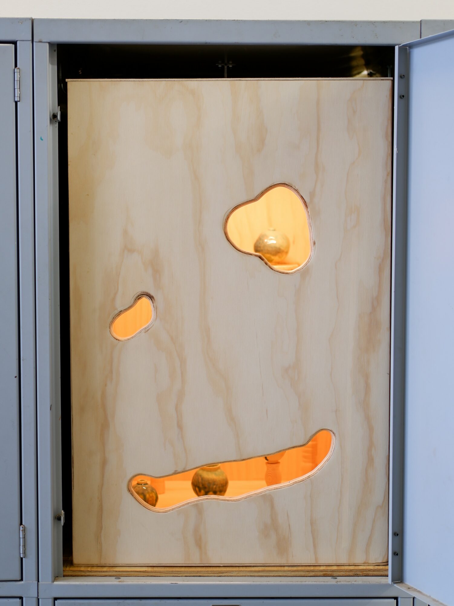 Wooden panel with cutouts and orange accents, enclosed in a metal frame, possibly part of a game or display.