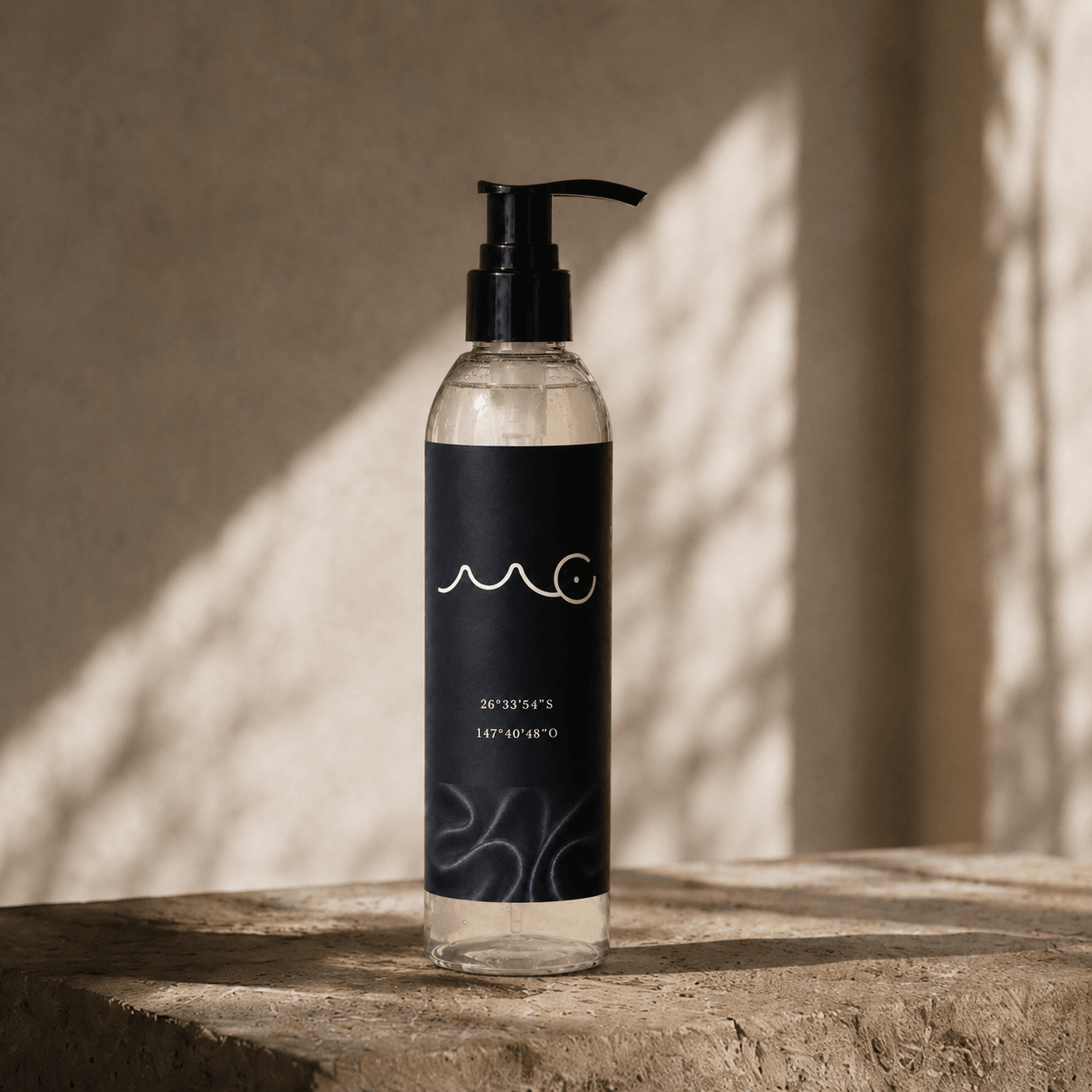 Clear bottle with black pump dispenser, label with white wave design, placed on wooden surface, sunlight and shadow background.