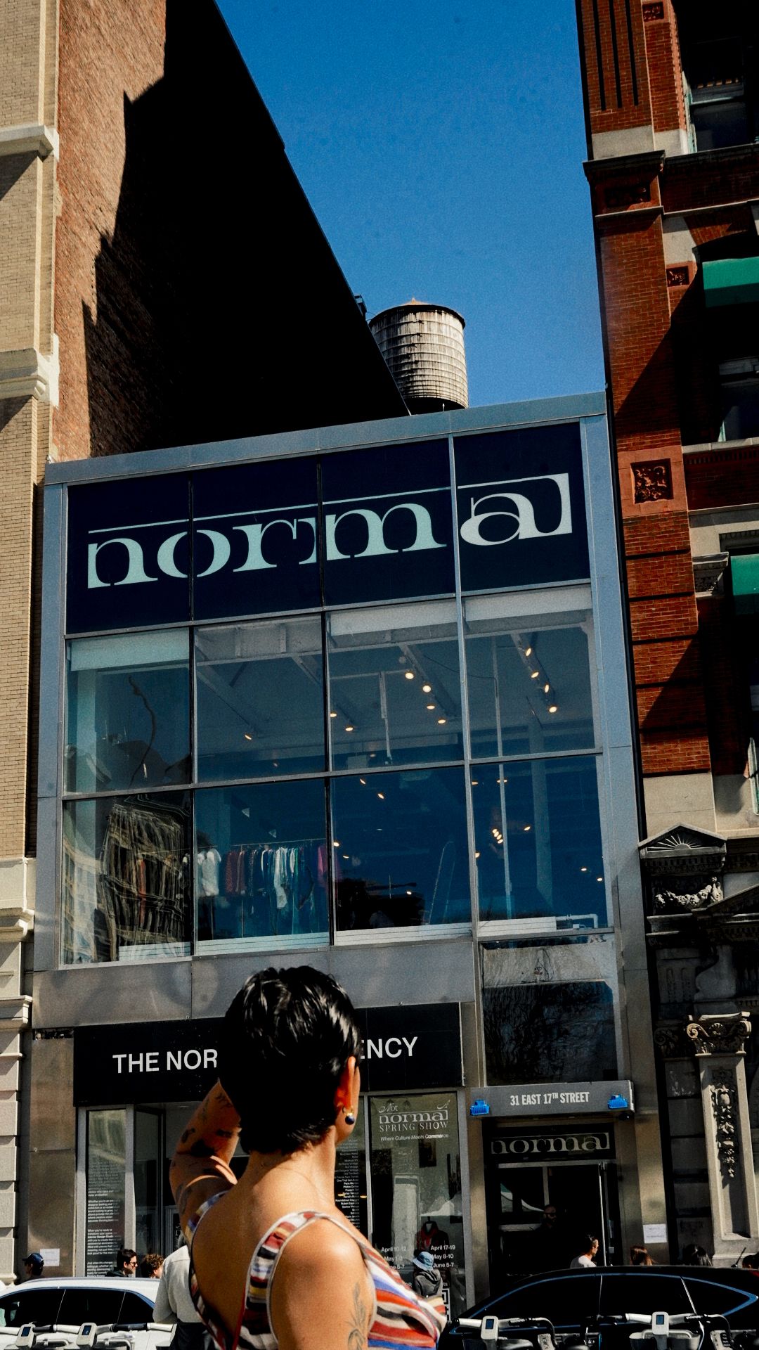 People standing outside a building with a large glass window and a sign that reads 'The North Agency'.