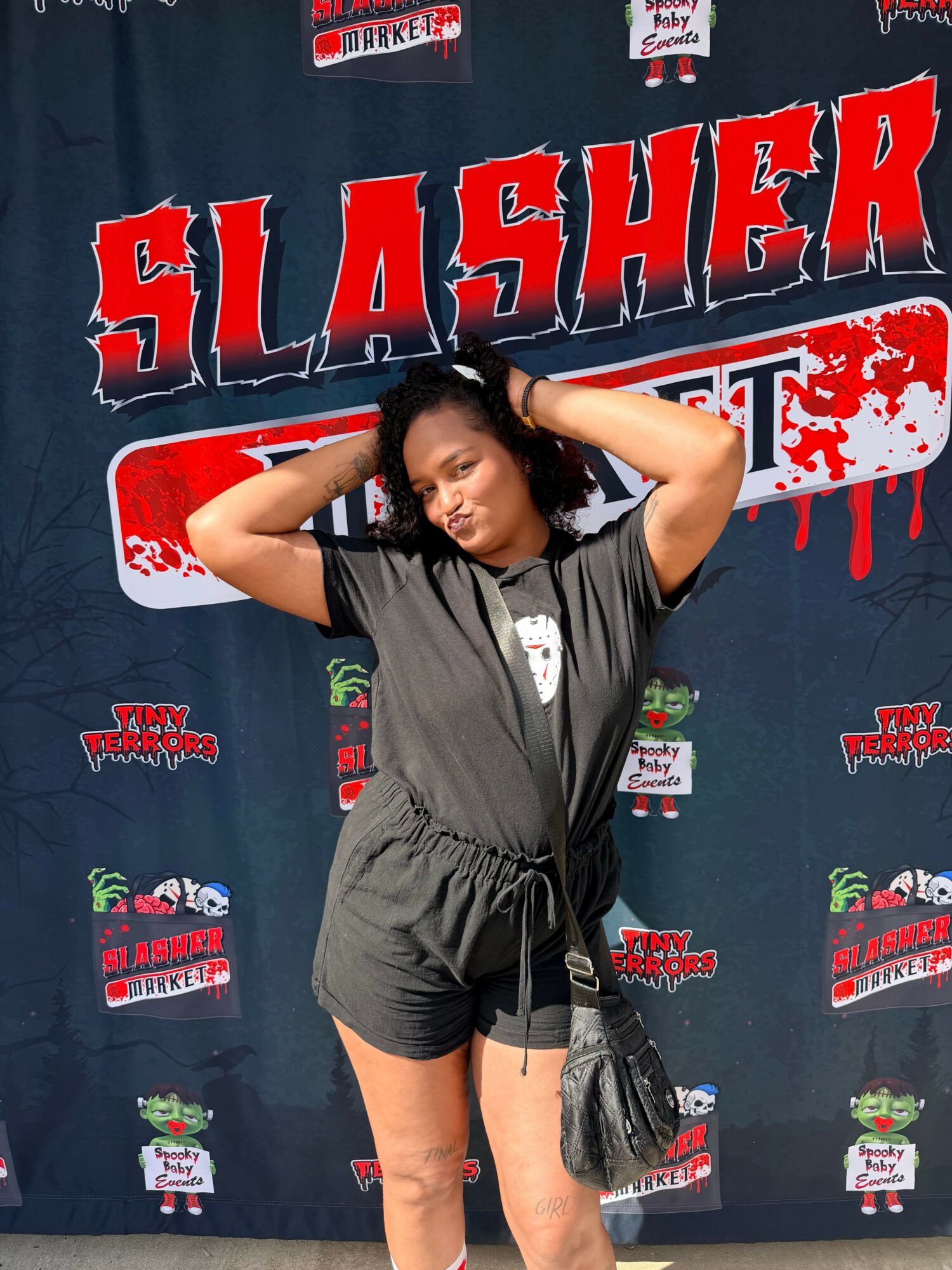 Young person lying on a table with arms behind head, wearing a black sports outfit, in front of a promotional backdrop.
