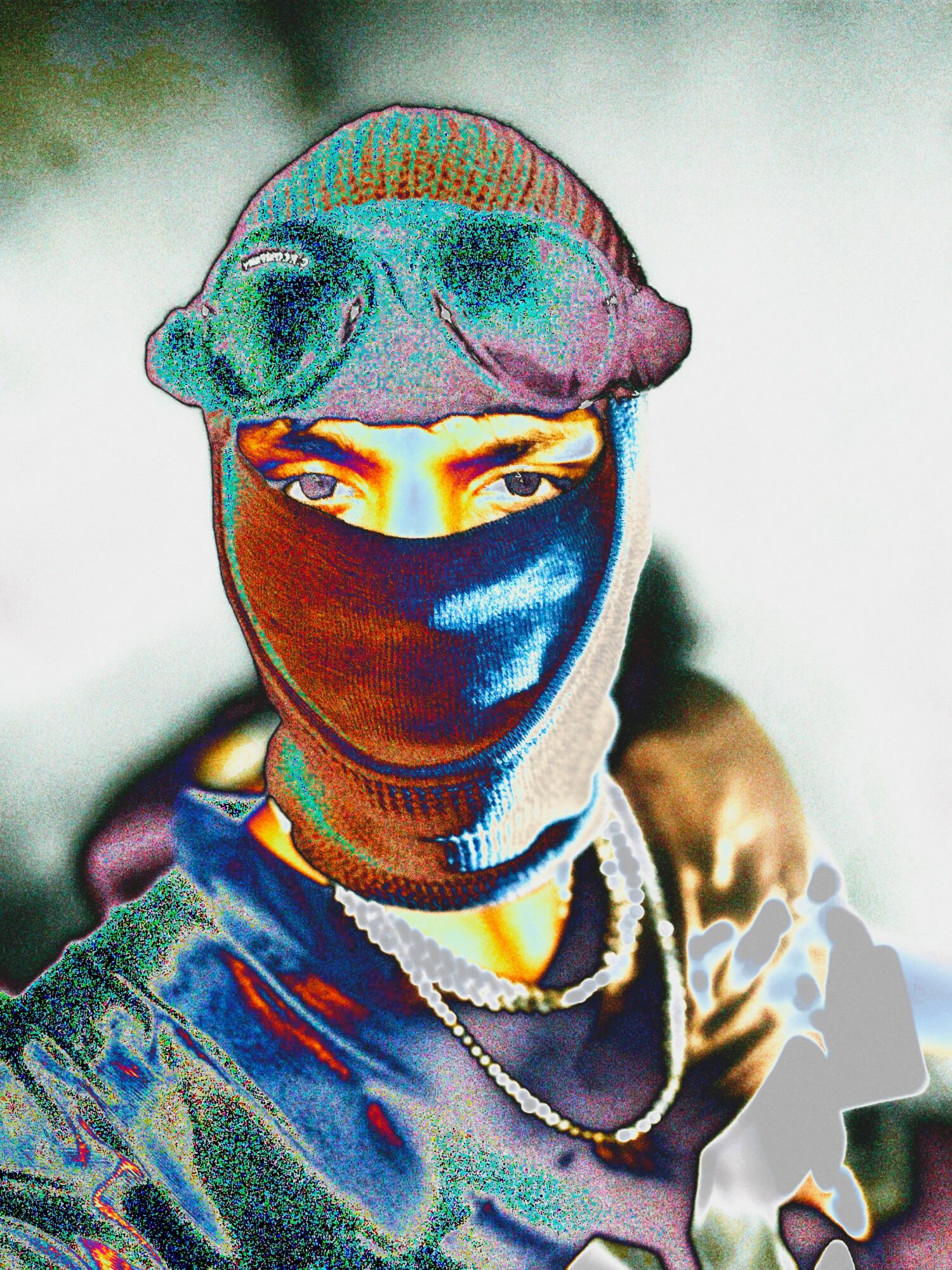 Person wearing a colorful hat and face covering, with visible eyes and jewelry, looking directly at the camera.