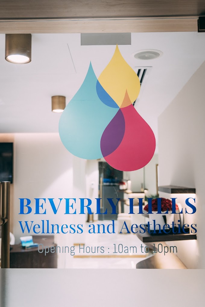 Colorful teardrop-shaped hanging decorations in blue, yellow, purple, and red above a wellness center reception area.
