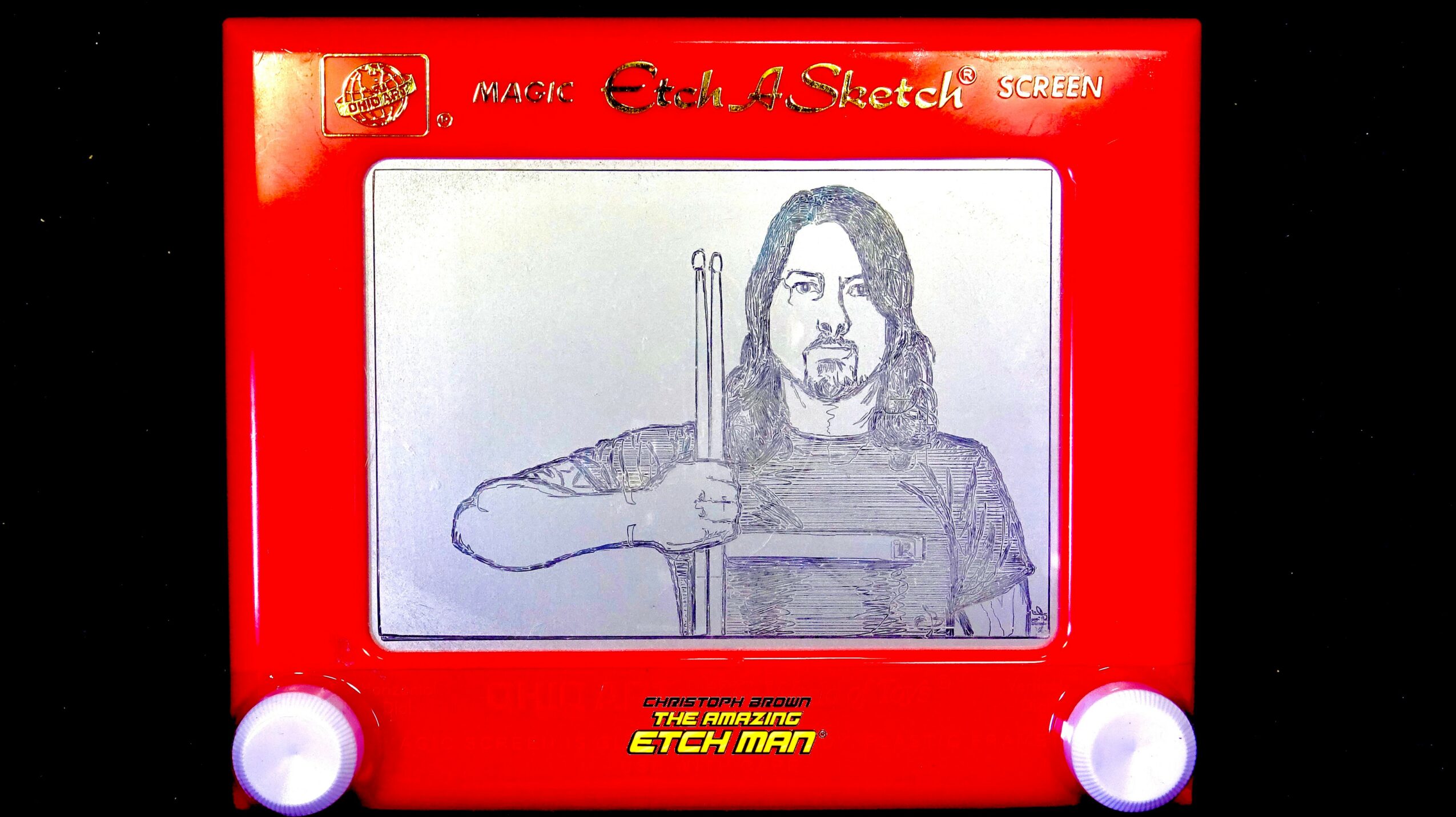 Drawing of a person with long hair holding two swords, displayed on a red ETCH A SKETCH box, with a white background.