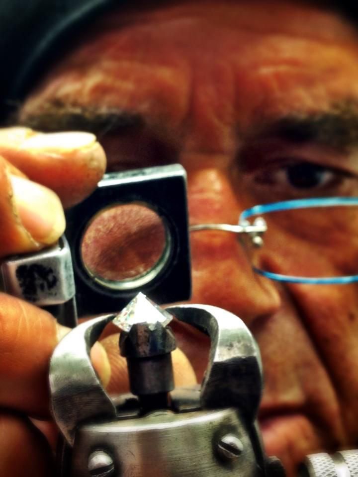 Close-up of a person holding a small makeup compact with a mirror, face partially visible, wearing glasses, with a dark background.