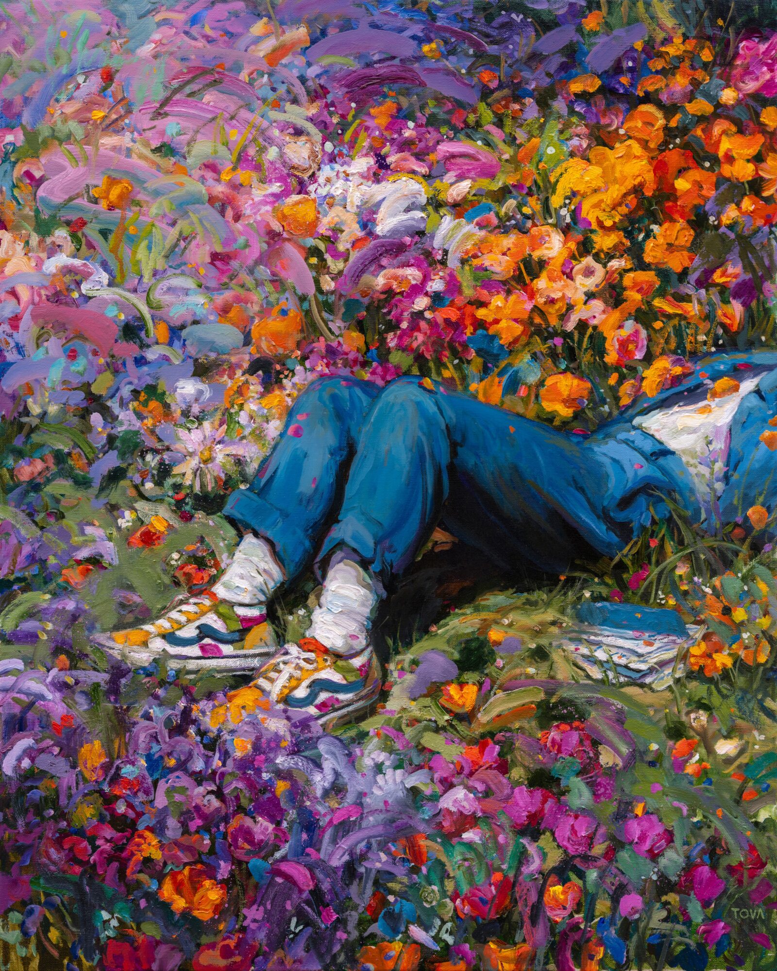 Person lying among colorful flowers, wearing blue jeans, sneakers, and a blue jacket, with a book nearby.