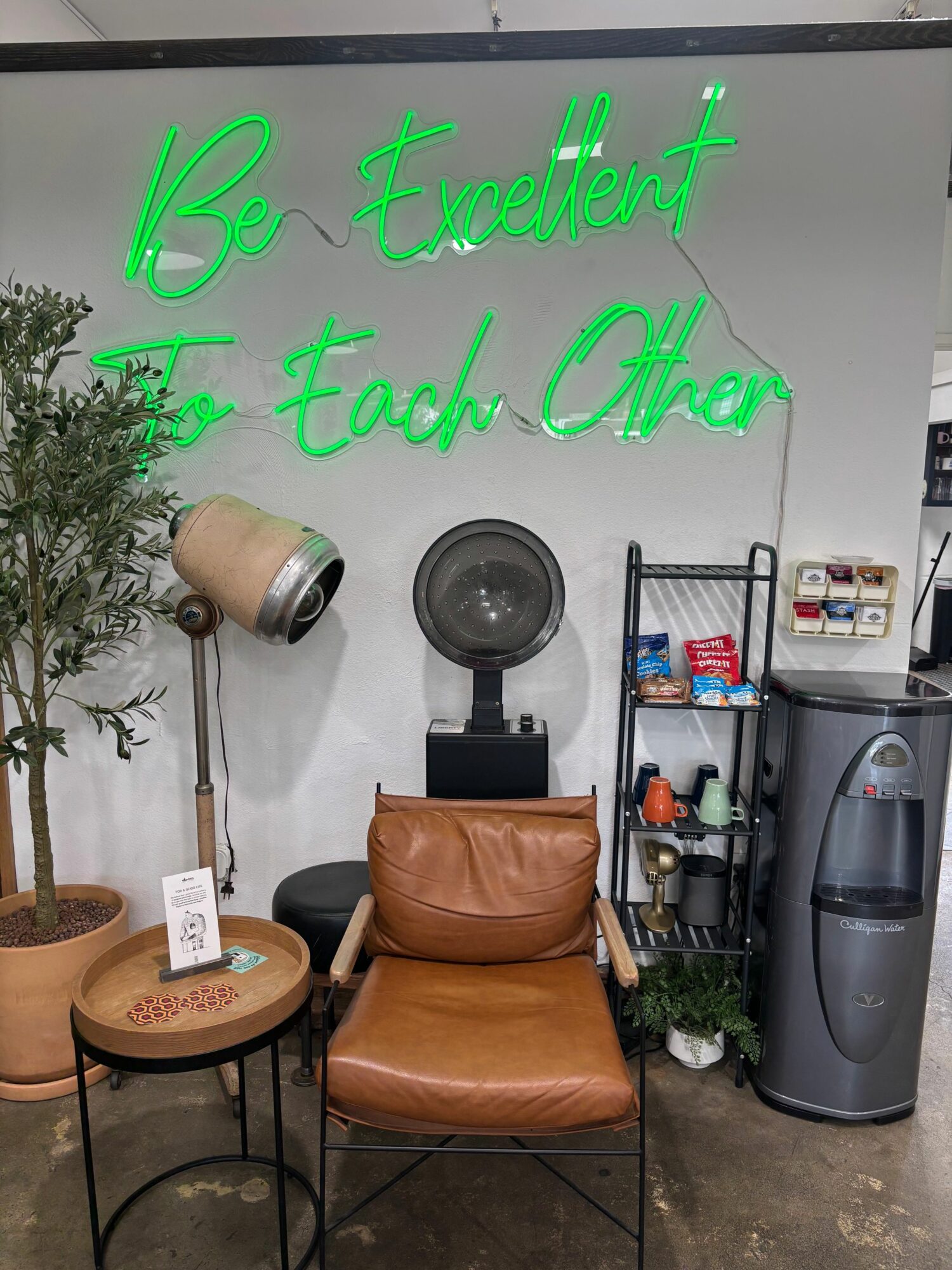Neon green text on wall reads 'IB twerkx' and 'Fool Out'. Room has a brown chair, small table, and various appliances.