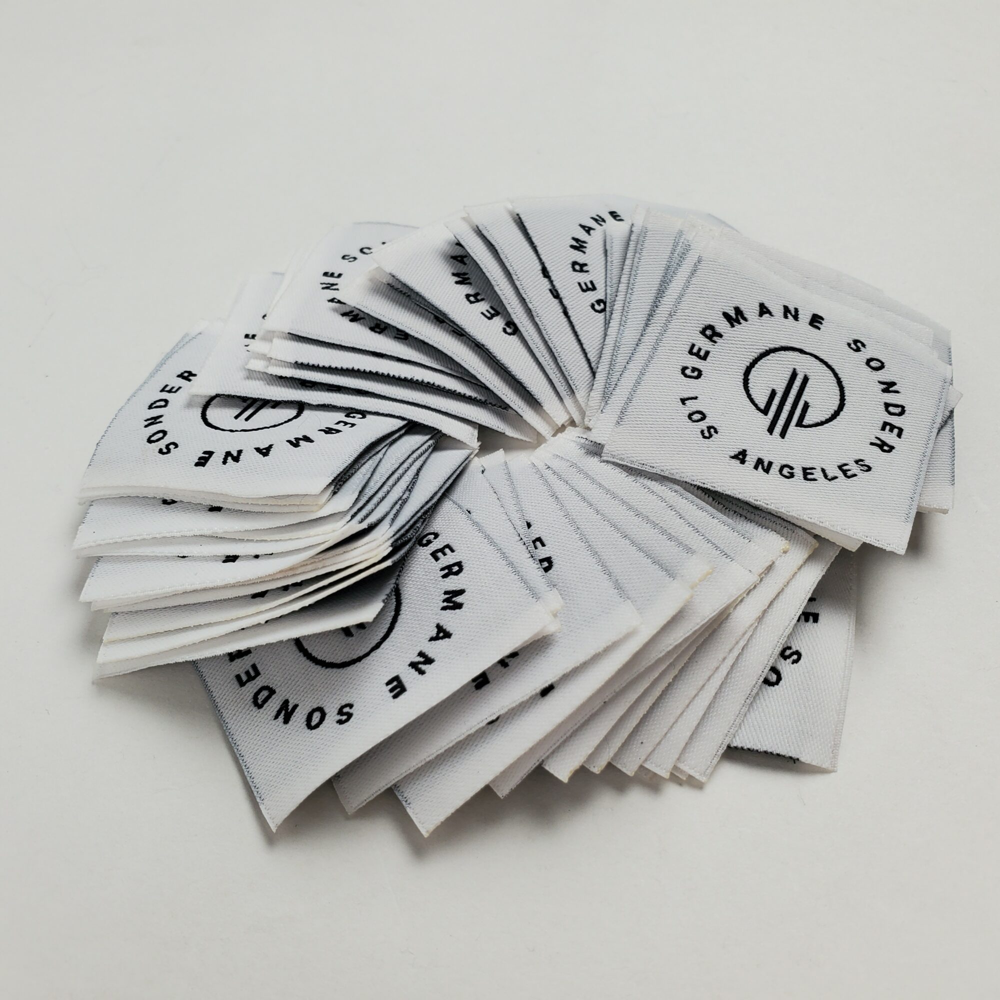 Multiple small cards with a logo and text, fanned out on a white surface.